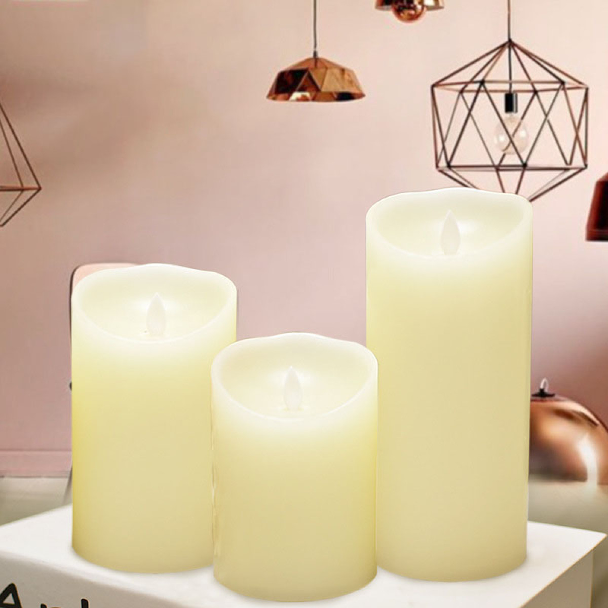 Trois bougies LED couleur crème de hauteurs variées se tiennent côte à côte.