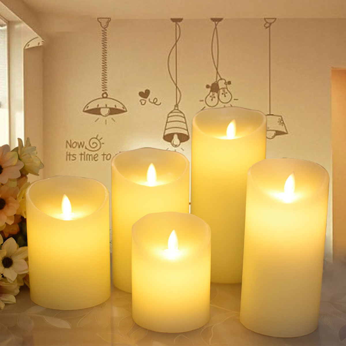 Cinq bougies LED allumées de tailles variées sur une table.