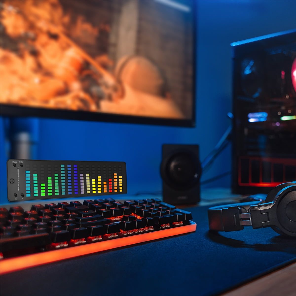 Gaming-Setup mit RGB-Tastatur, Equalizer-Display, Kopfhörern, PC und Monitor.