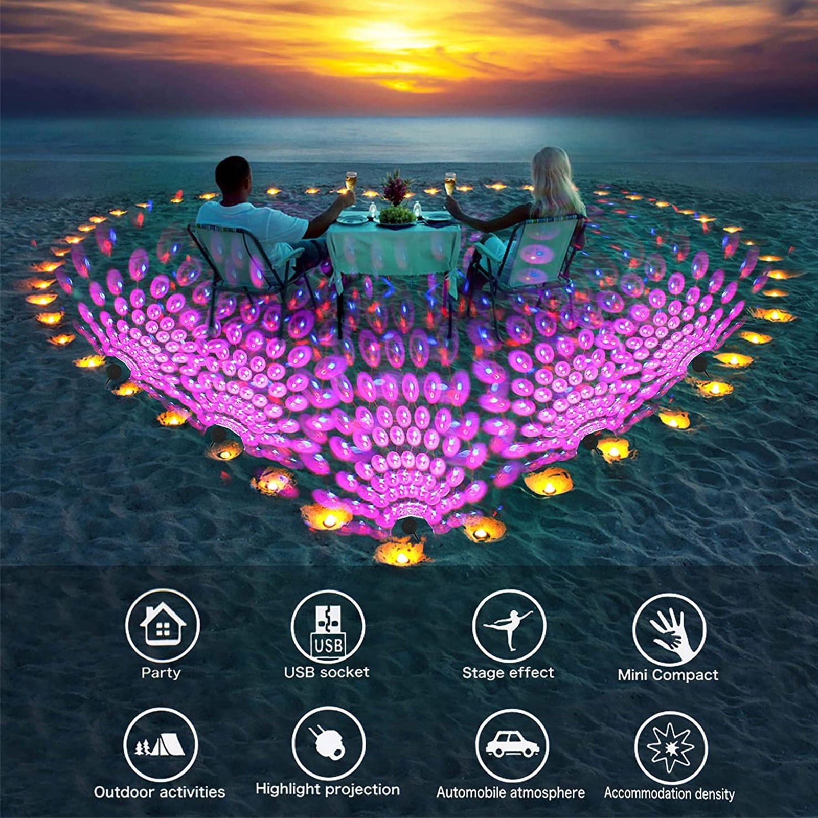 Paar isst am Strand bei Sonnenuntergang, umgeben von Lichtern.