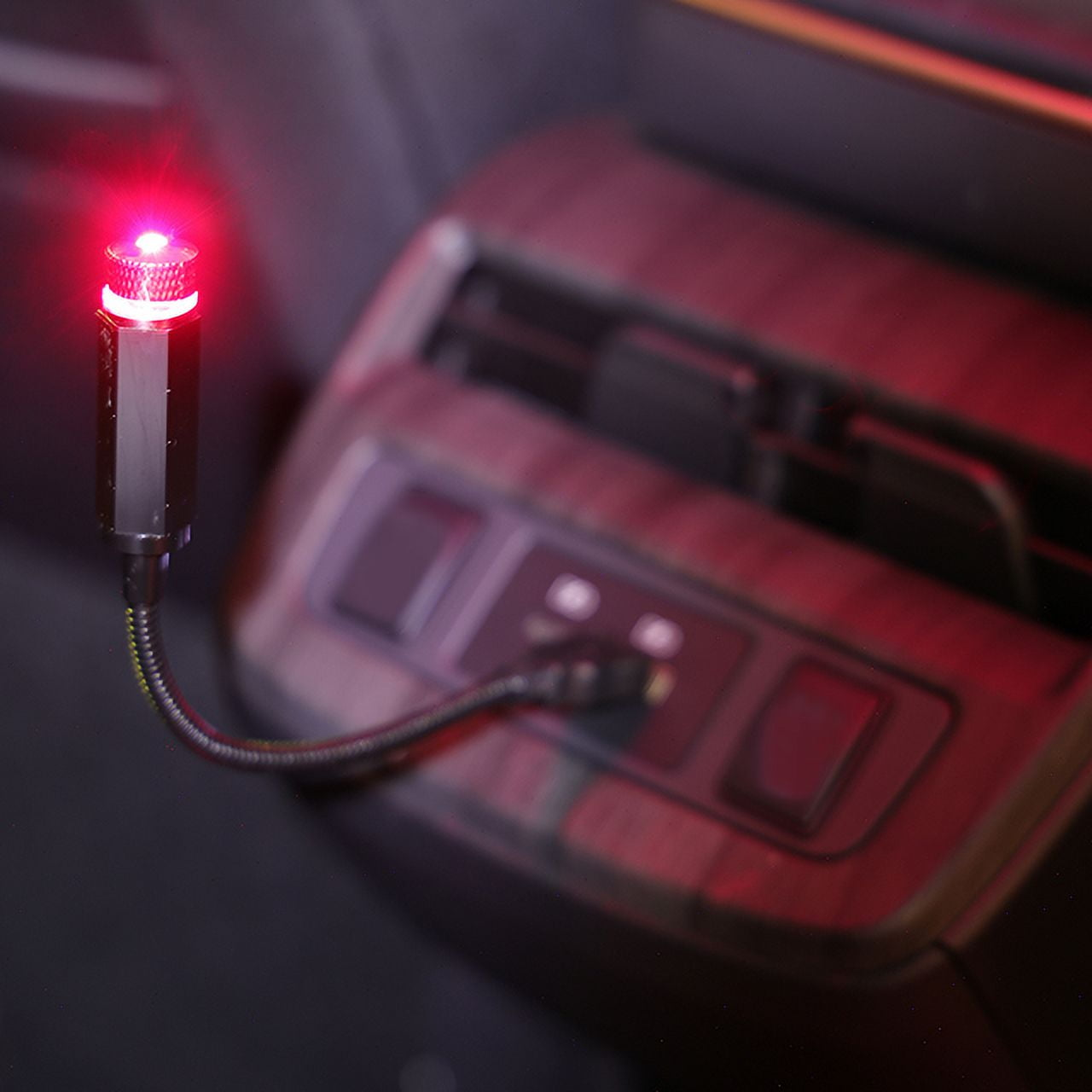 Ein kleiner roter Sternenprojektor leuchtet auf einem Armaturenbrett.