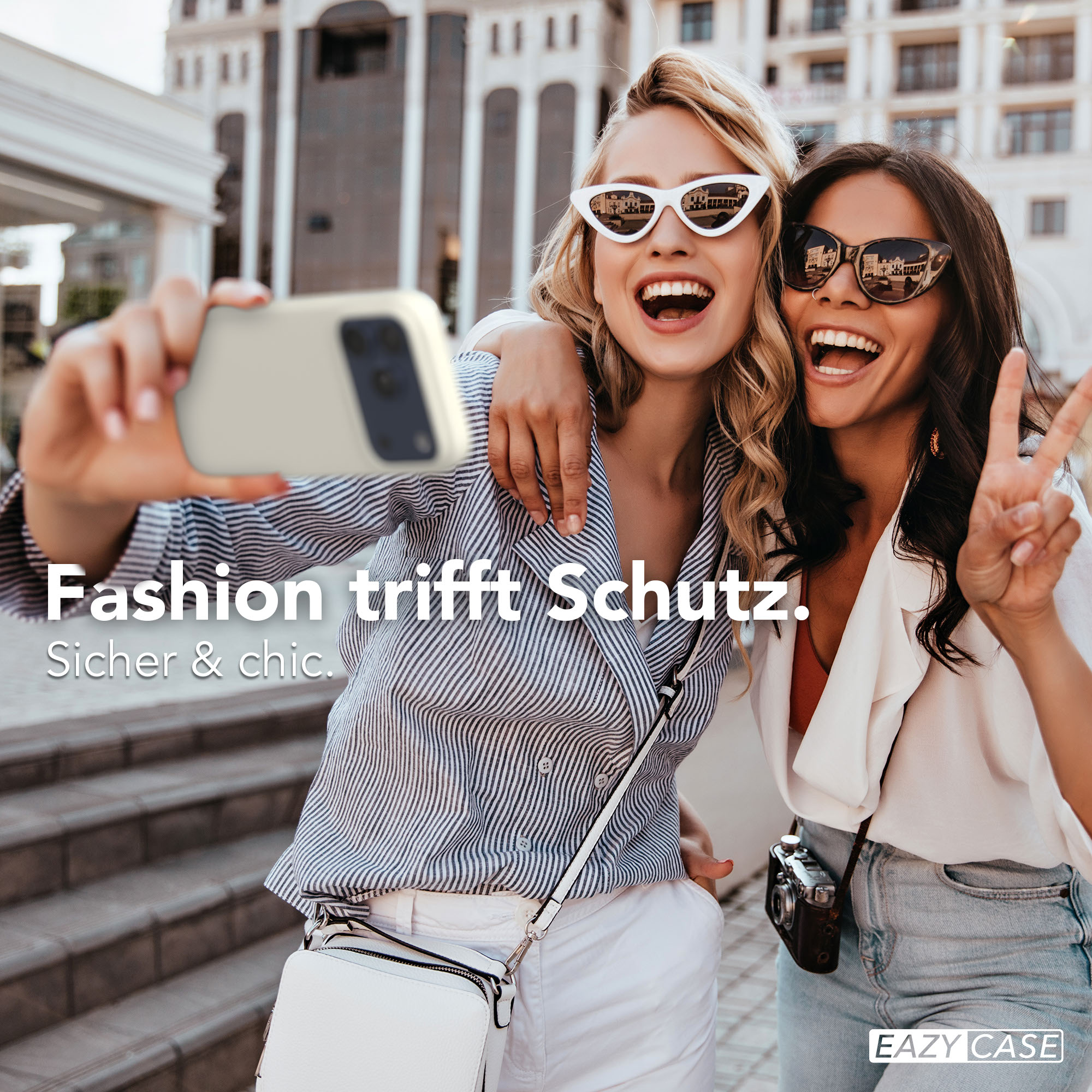 Zwei Frauen machen ein Selfie mit einem Handy. Sie tragen Sonnenbrillen und lächeln.