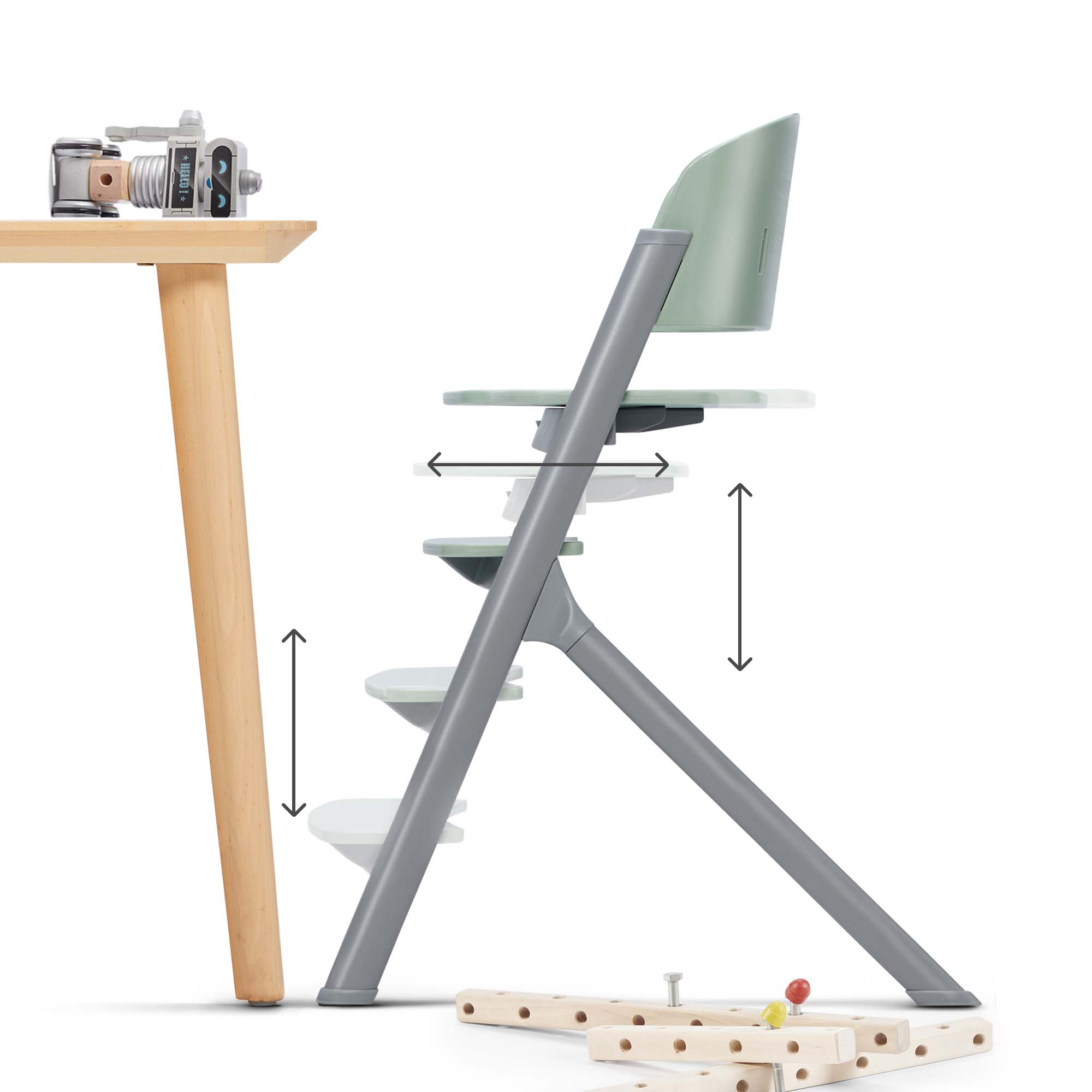 Ein grüner Hochstuhl mit grauen Beinen und verstellbaren Elementen steht neben einem Holztisch.