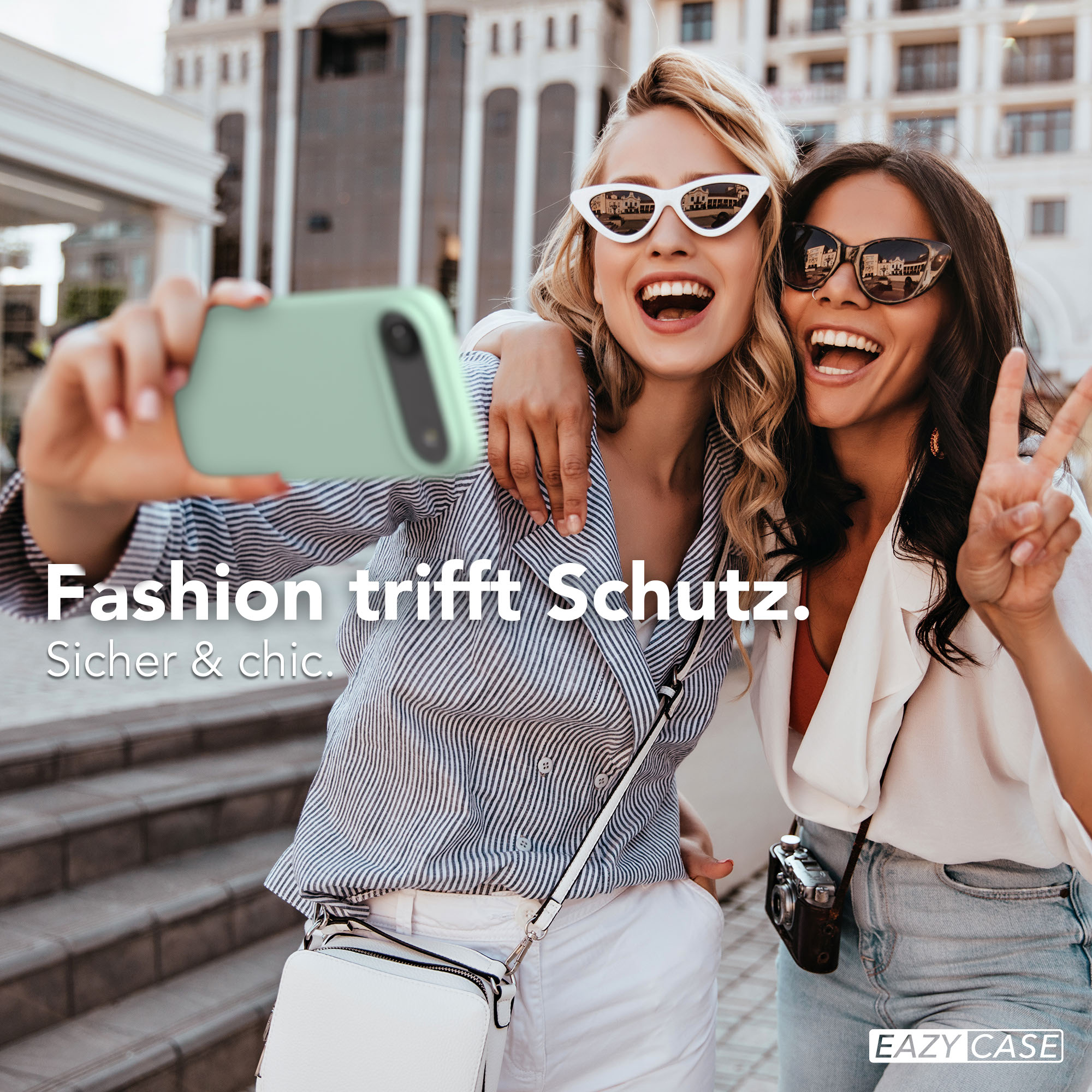 Zwei lachende Frauen machen ein Selfie mit einem mintgrünen Handy.