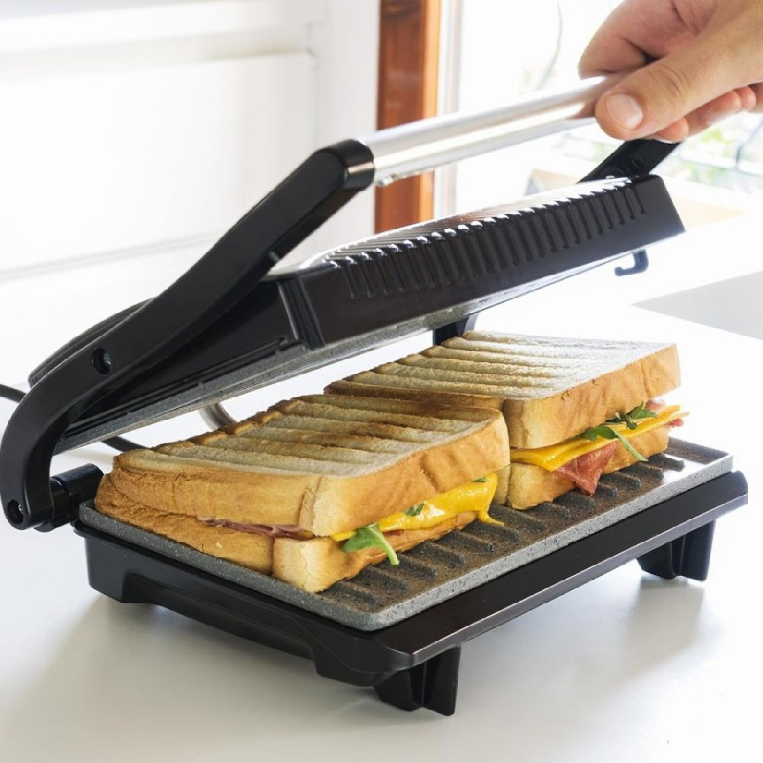 Una mano chiude un tostapane con due toast all'interno.