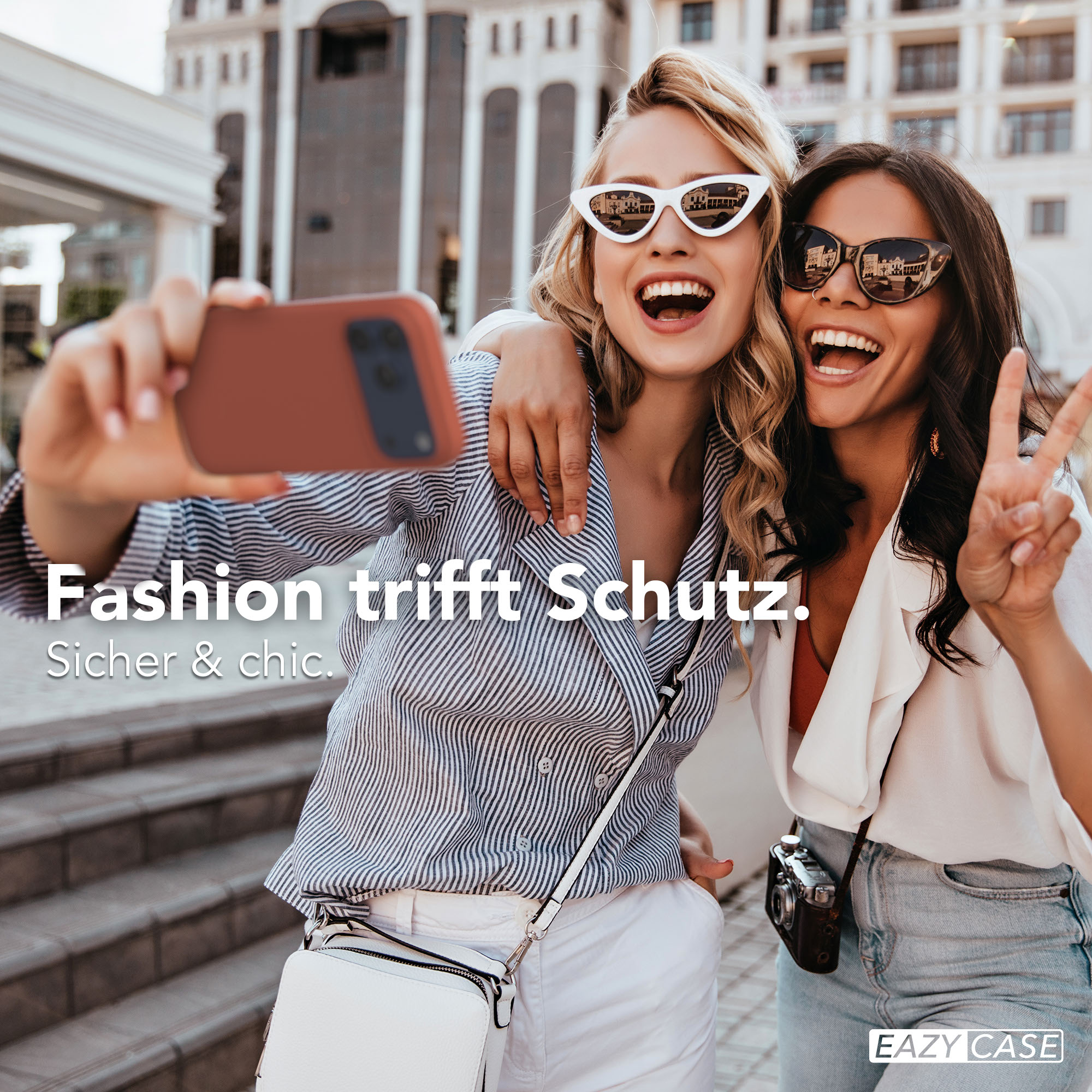 Zwei Frauen machen ein Selfie mit einem Handy. Eine winkt mit der Hand.
