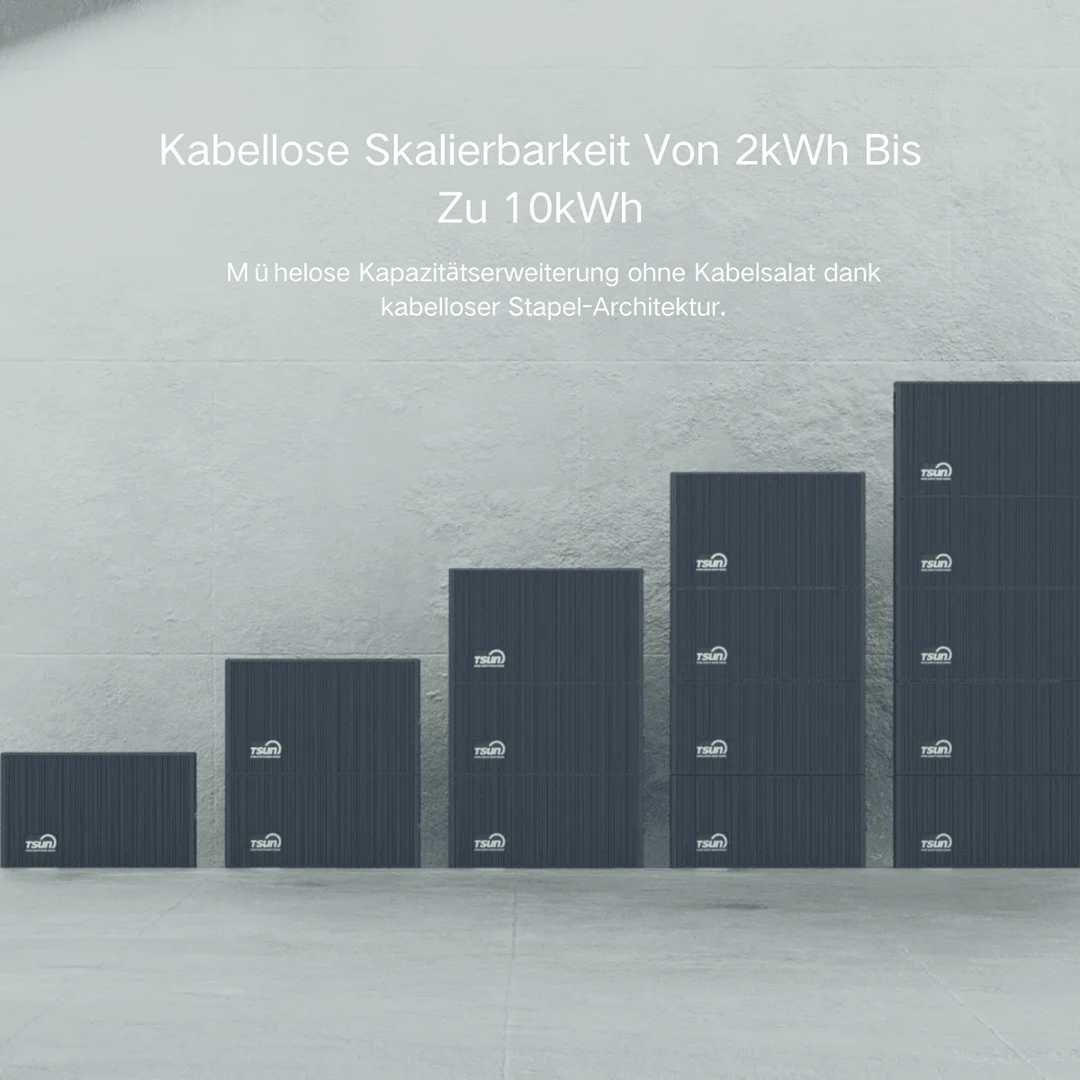 Dunkelgraue Stapel von Energiespeichern in steigender Größe auf Betonboden.