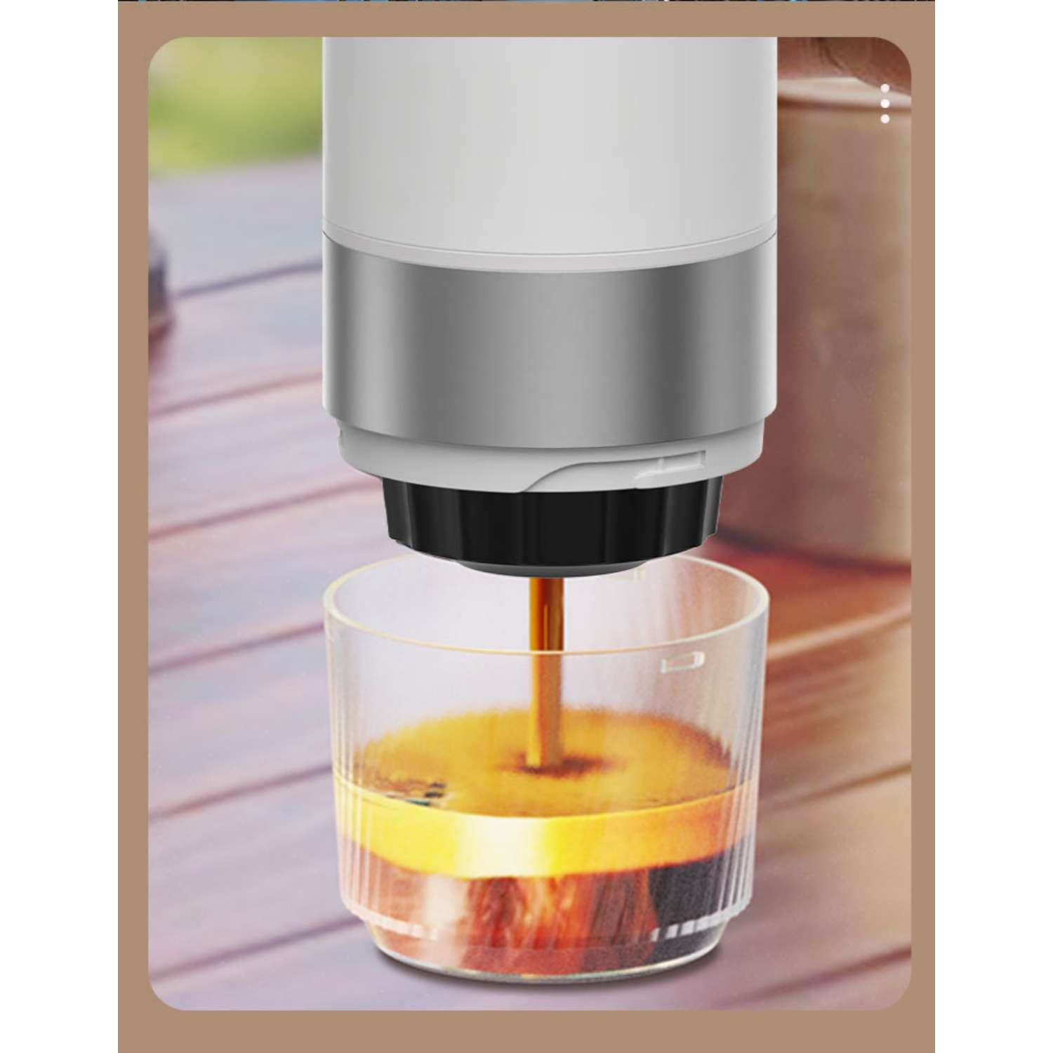 Kaffee fließt aus einer Maschine in ein Glas auf einem Holztisch.