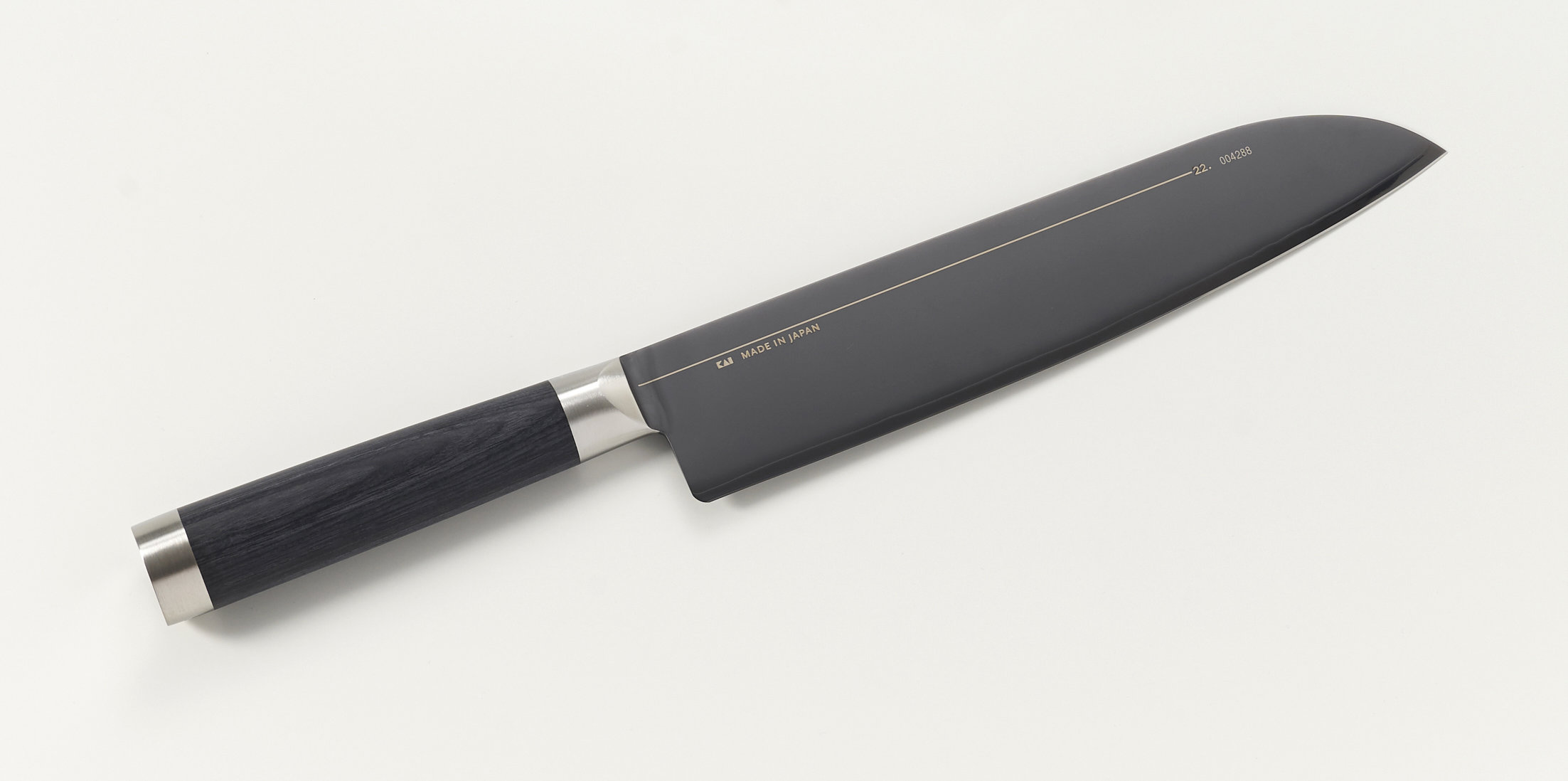 Ein schwarzes Kochmesser mit Holzgriff und silberner Zwinge, auf weißem Grund.