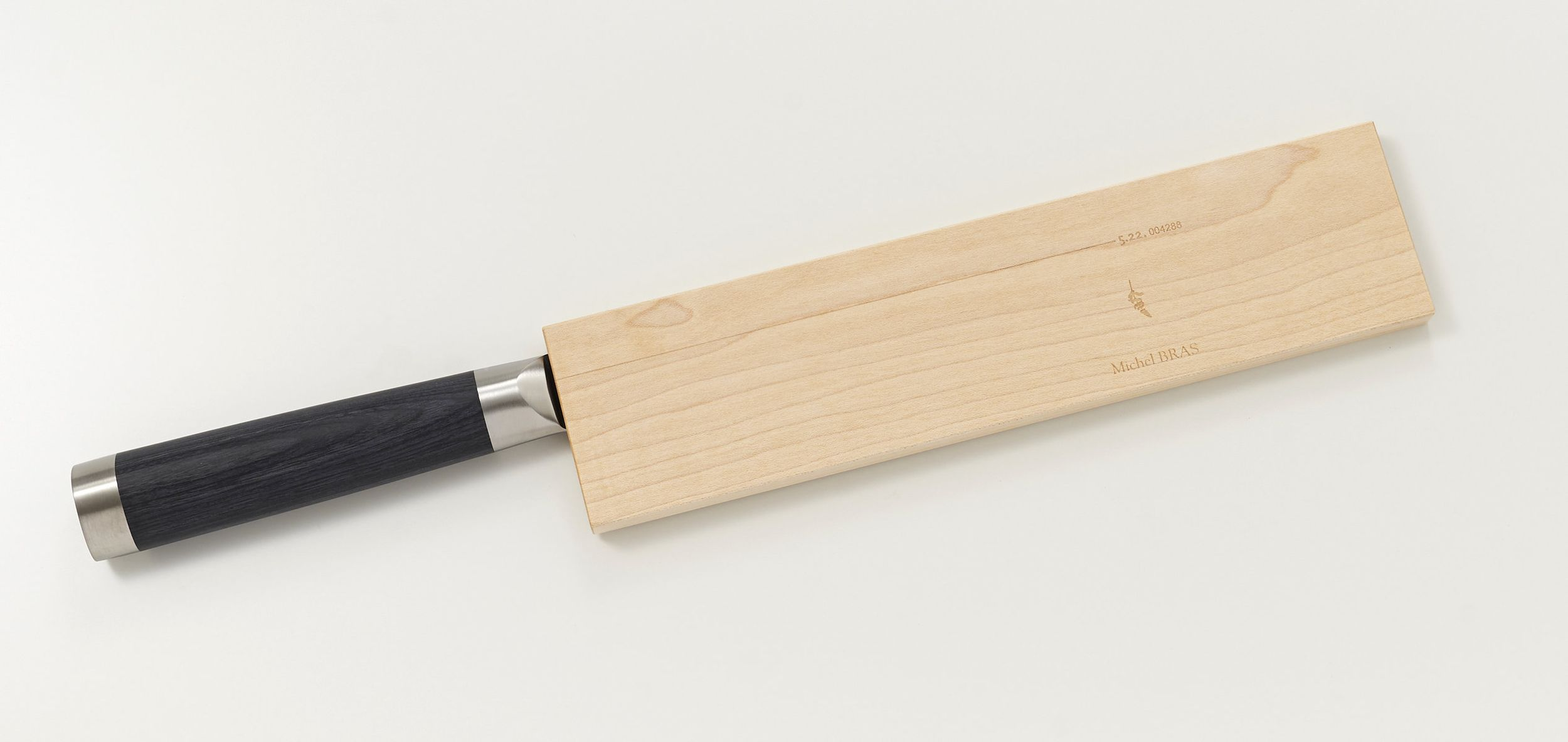 Ein Messer mit schwarzem Griff und einer Holzschutzhülle mit Gravur.