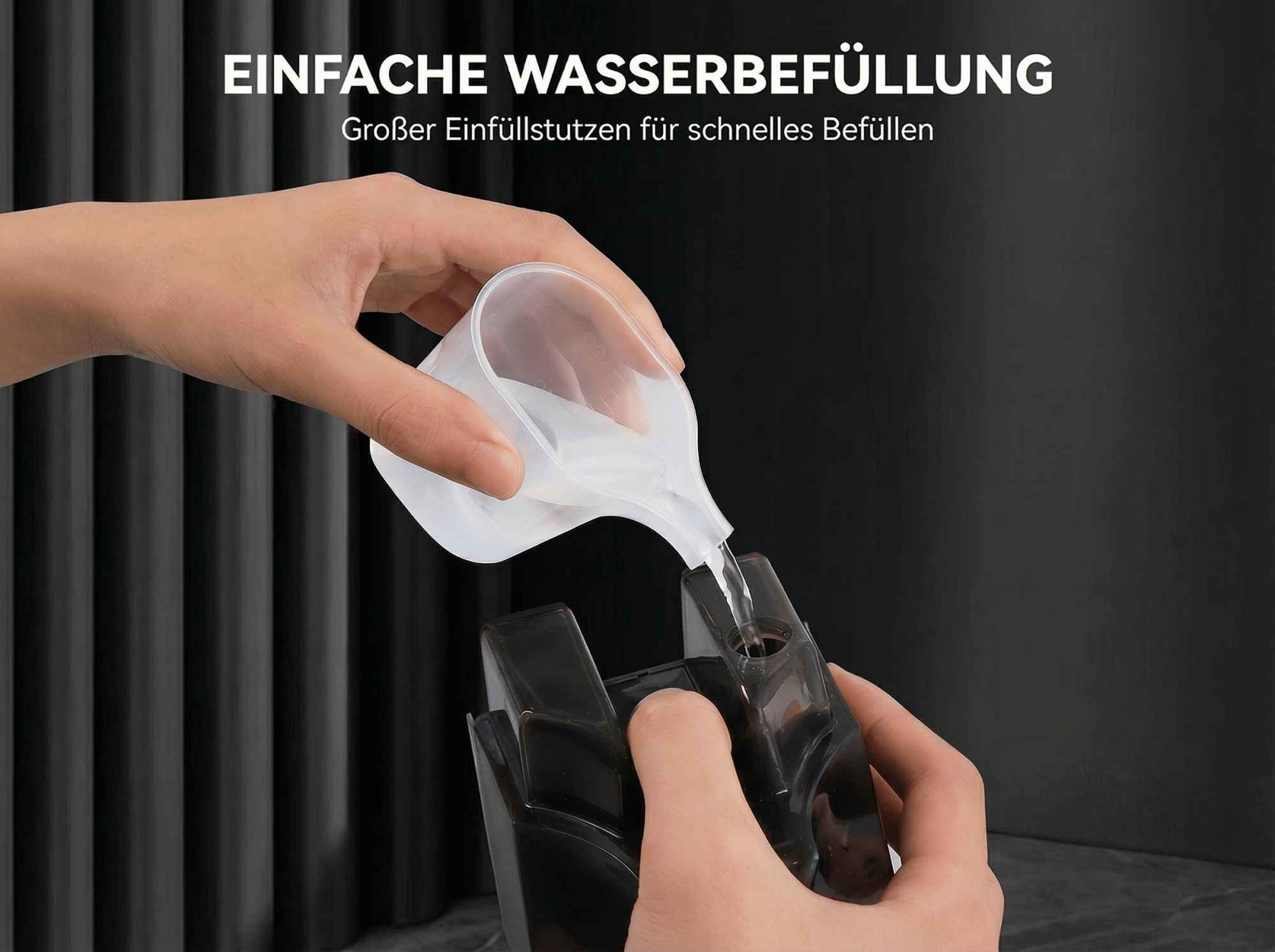 Eine Hand gießt Wasser aus einem Messbecher in ein schwarzes Gerät.