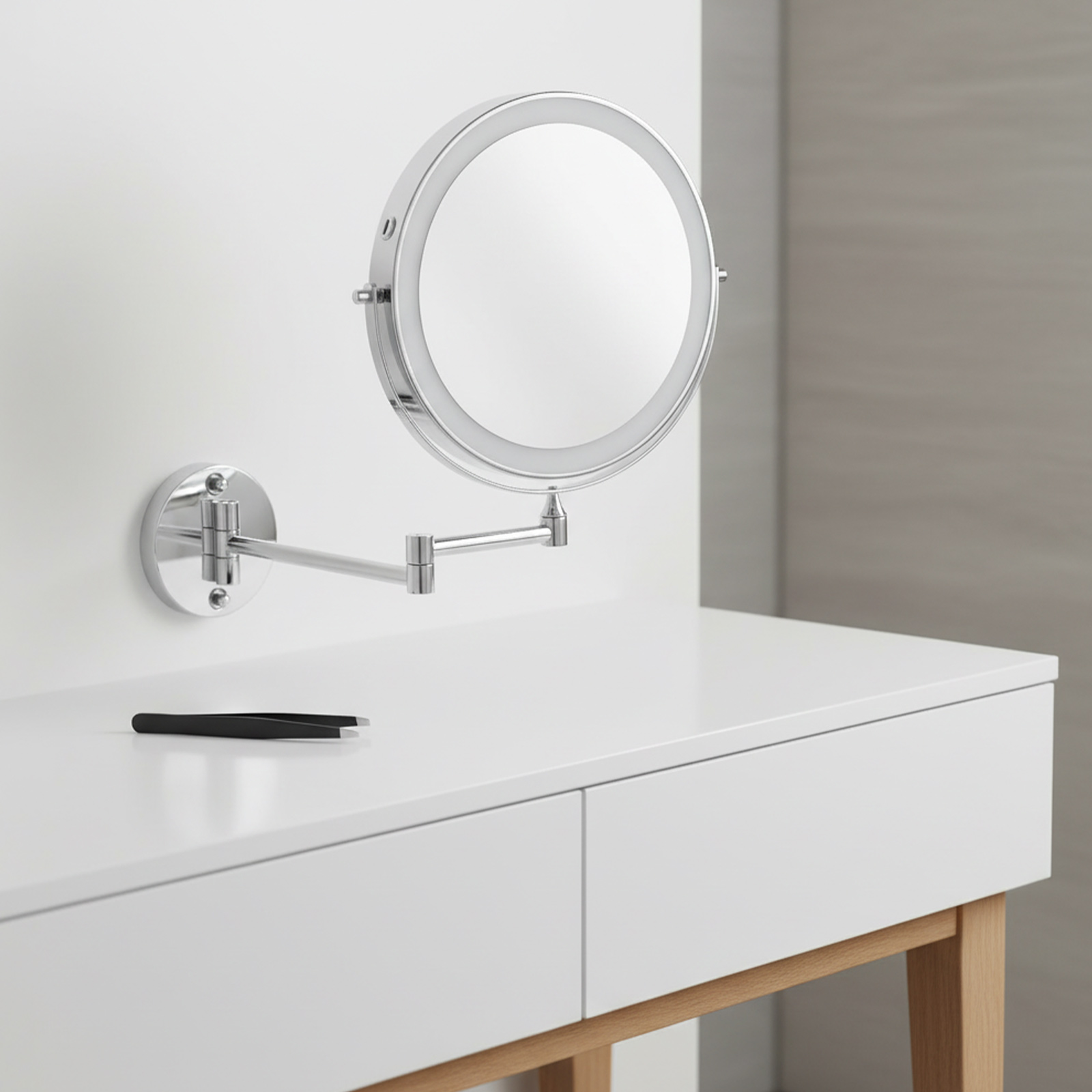 Ein Kosmetikspiegel mit LED-Beleuchtung hängt über einer weißen Kommode mit Pinzette.