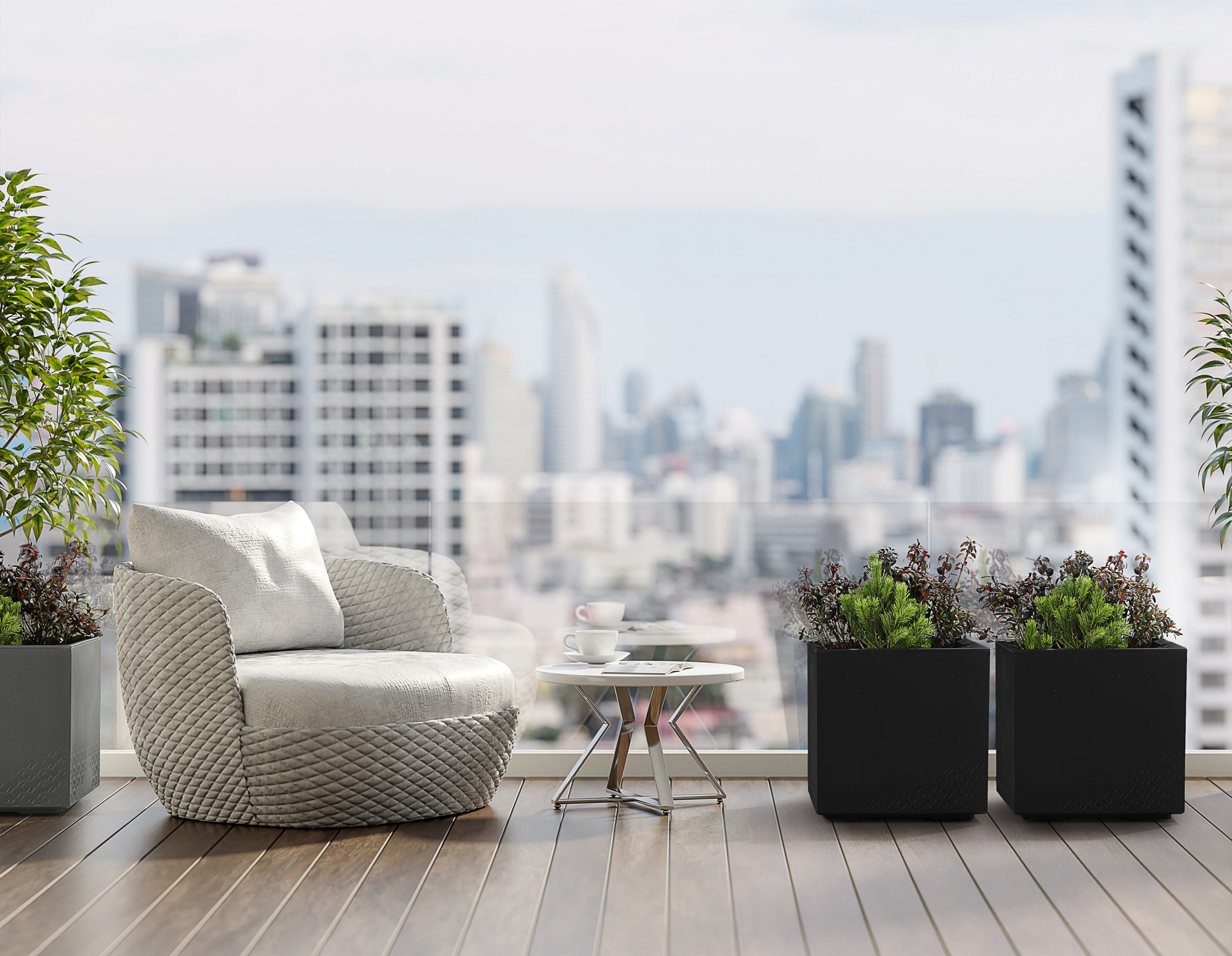 Ein Sessel und ein Tisch auf einem Balkon mit Stadtblick.