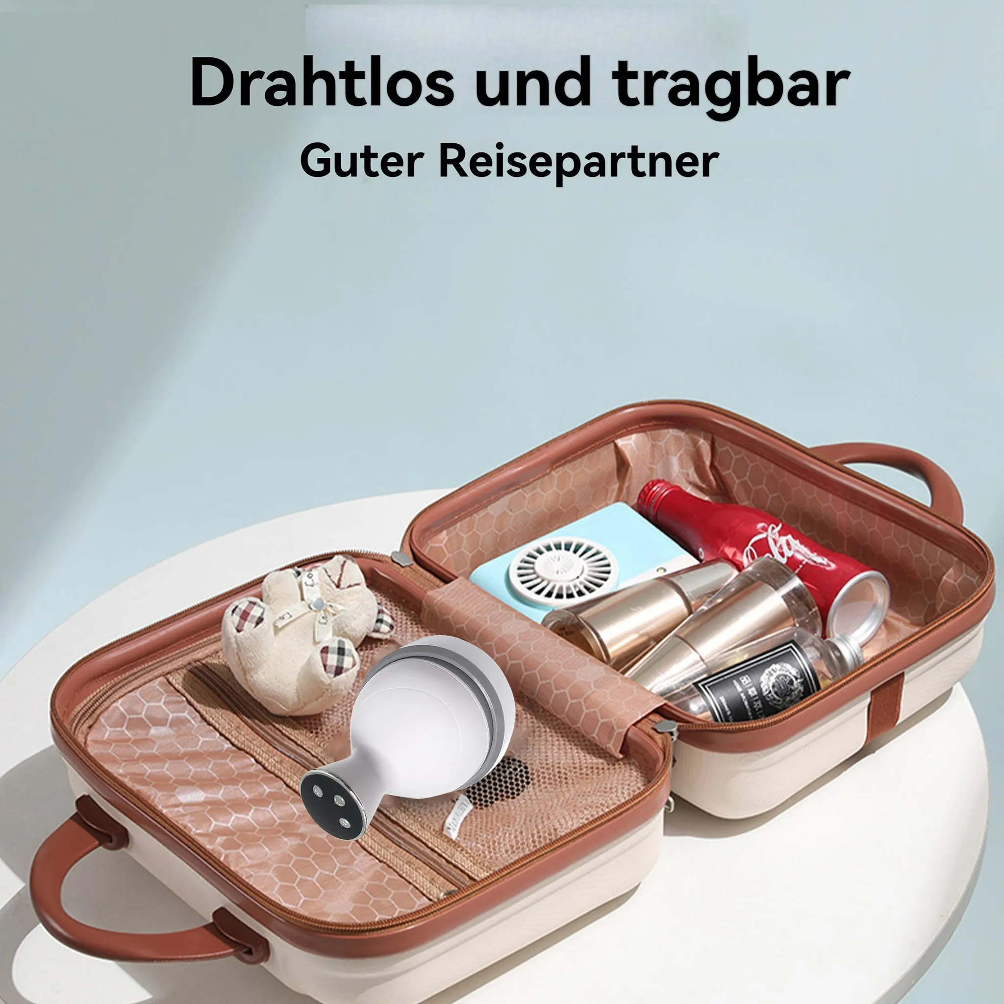Ein offener Koffer mit Kosmetika, einem Ventilator und einem Teddybär.