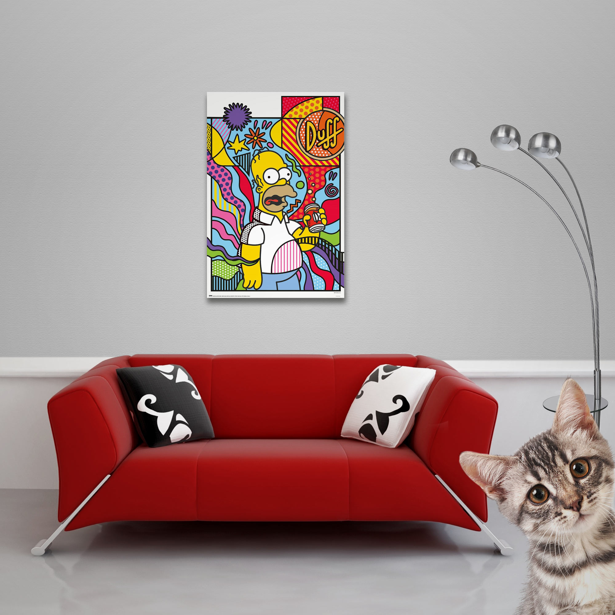 Ein Kater schaut neugierig auf ein Sofa mit einem Homer Simpson-Bild.