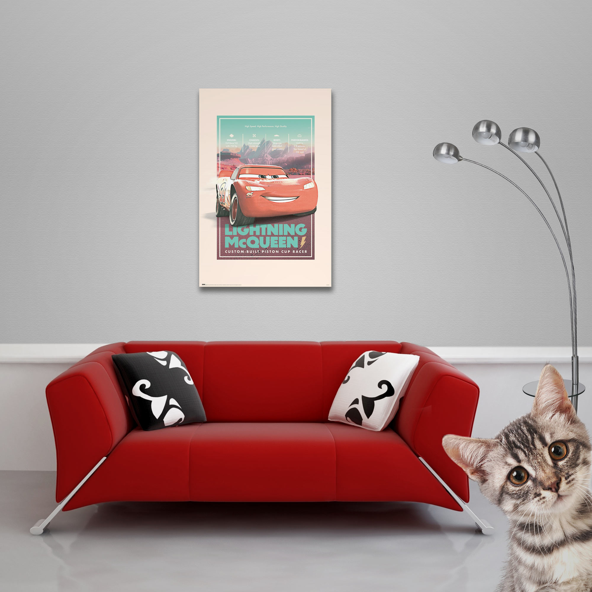 Ein rotes Sofa mit Kissen, ein Lightning McQueen Poster und eine Katze.