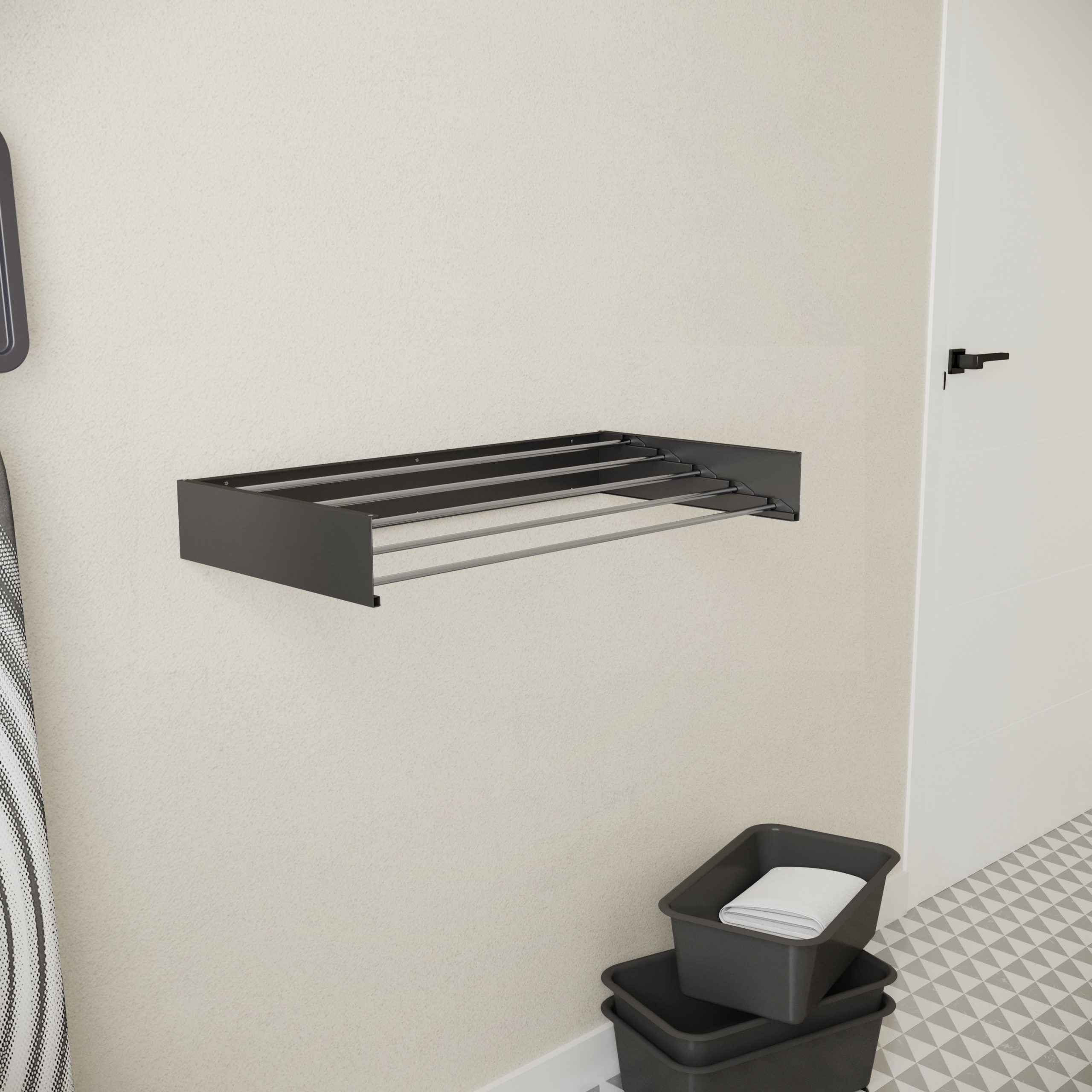 A dark wall-mounted drying rack with multiple bars above two grey baskets on a patterned floor.
