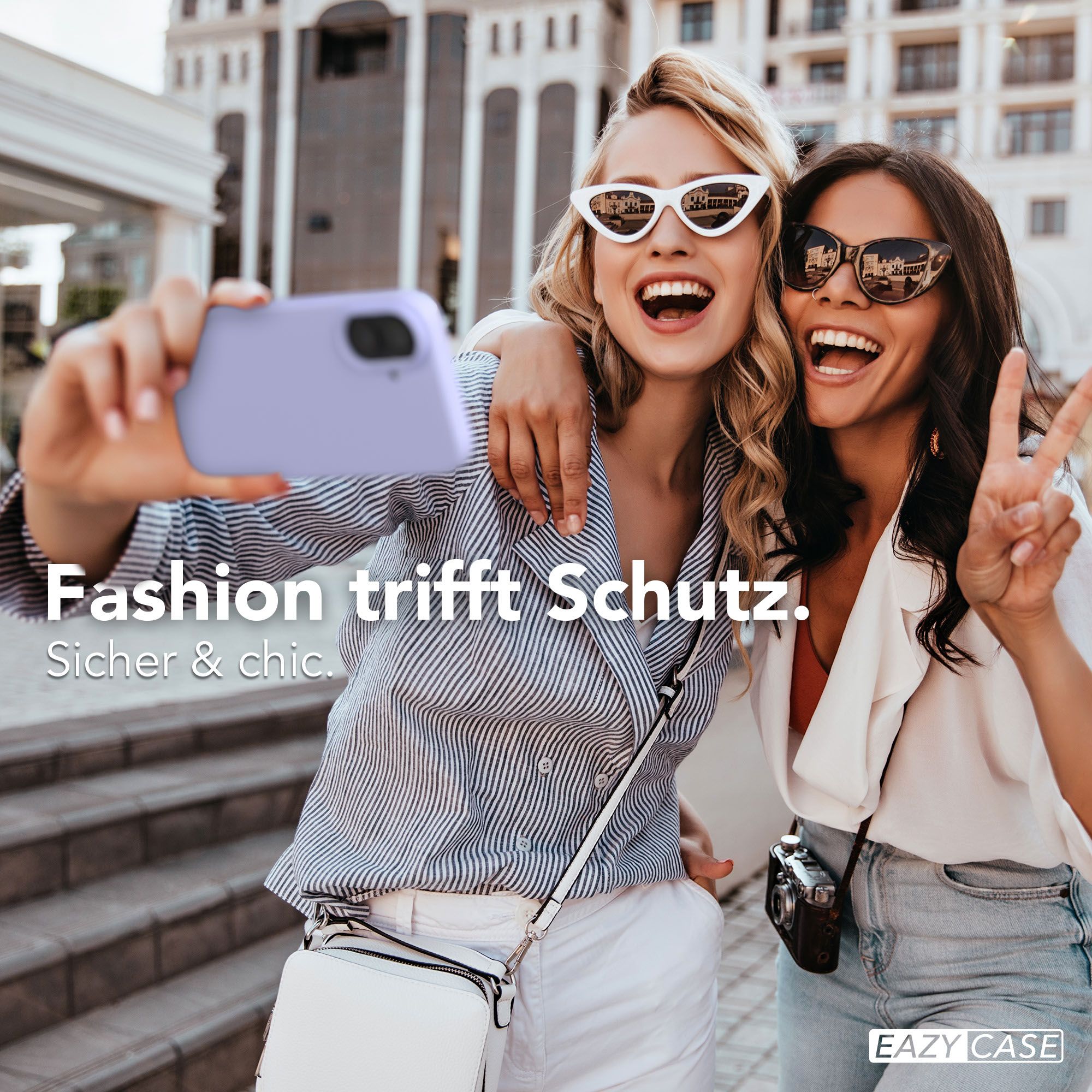 Zwei lachende Frauen machen ein Selfie mit einem lila Handy. Mode trifft Schutz.
