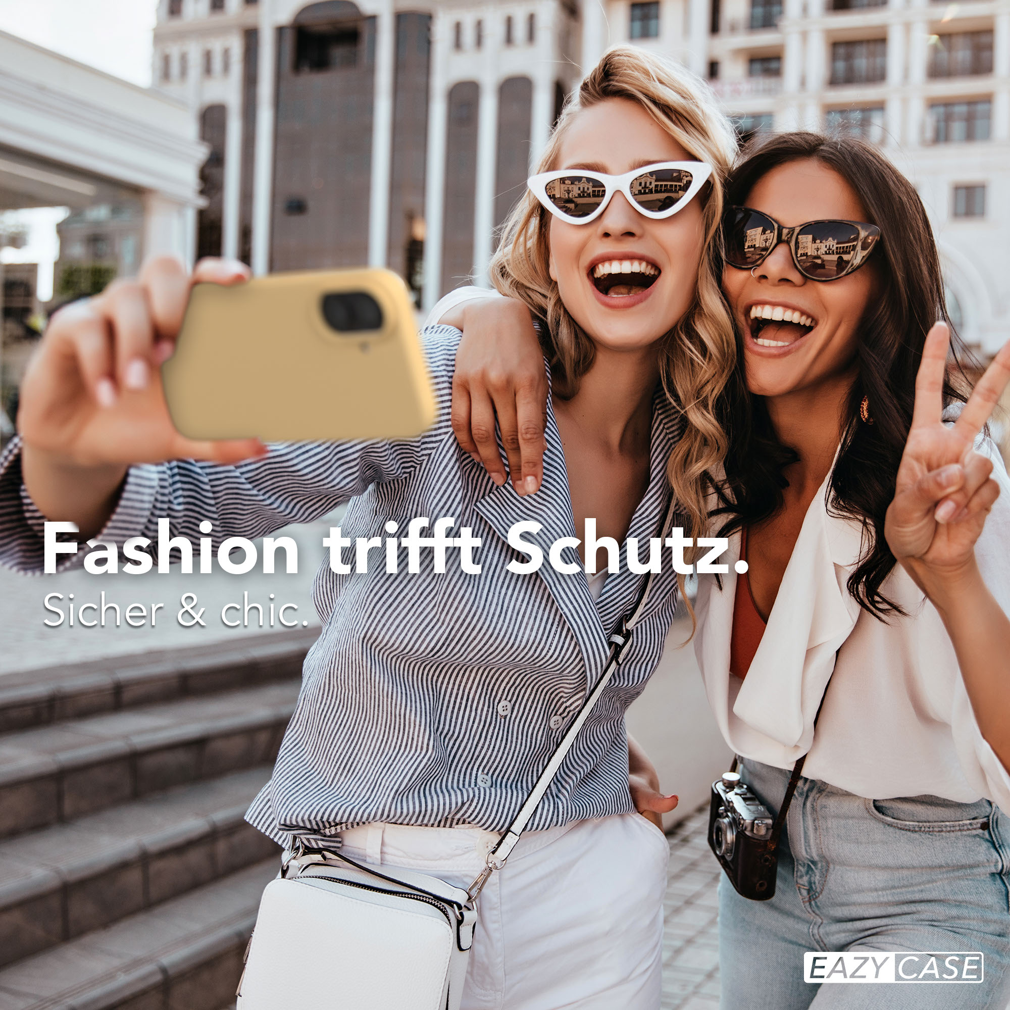 Zwei Frauen machen ein Selfie mit einem gelben Handy. Sie lachen.
