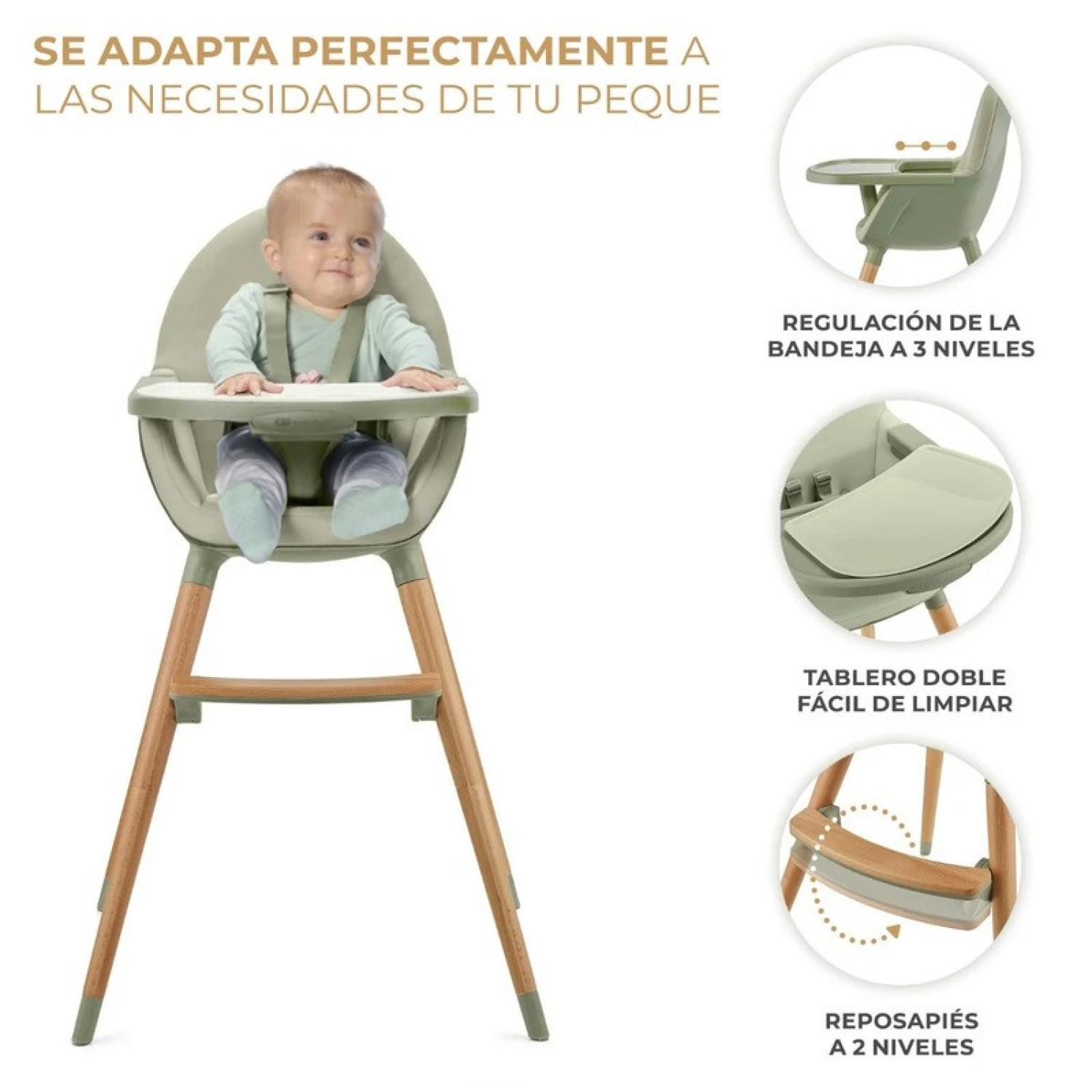 Baby sitzt in einem grünen Hochstuhl mit Holzbeinen. Details zeigen Tabletts und Fußstützen.