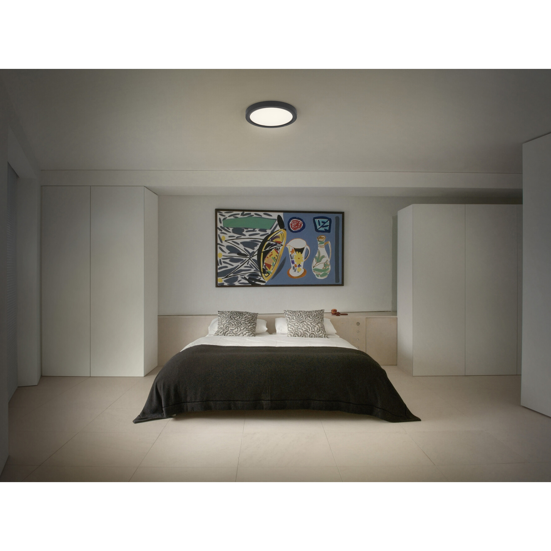 Ein Schlafzimmer mit einem Bett, Kunstwerk und Schränken.