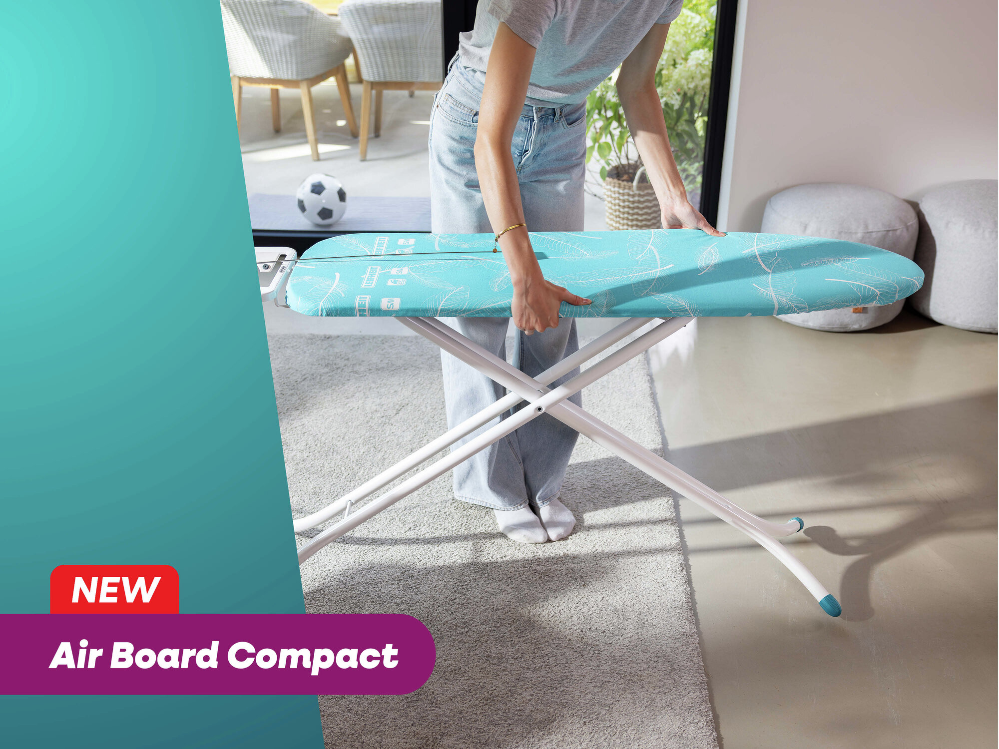 Eine Person stellt ein blaues Bügelbrett mit Blattmuster auf. Neu, Air Board Compact.