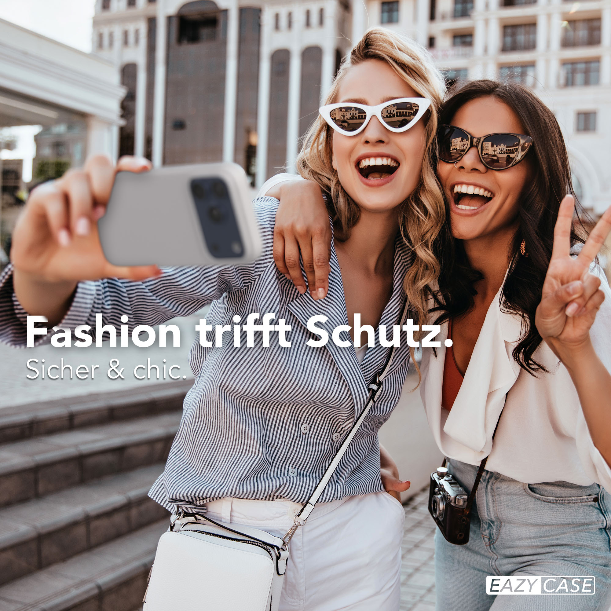 Zwei lachende Frauen machen ein Selfie mit einem Handy. Mode trifft Schutz.