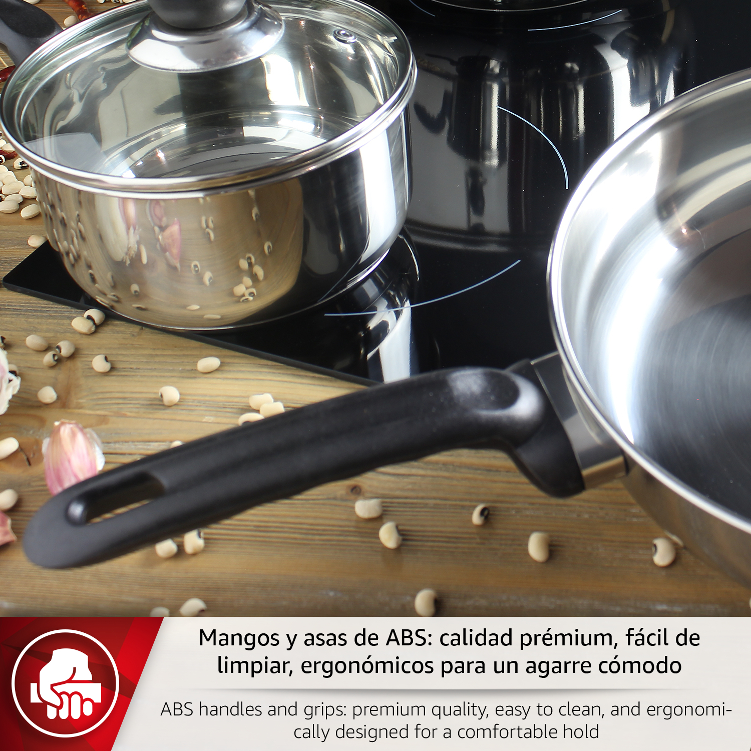 Ollas y sartenes de acero inoxidable con mangos negros sobre vitrocerámica con frijoles.