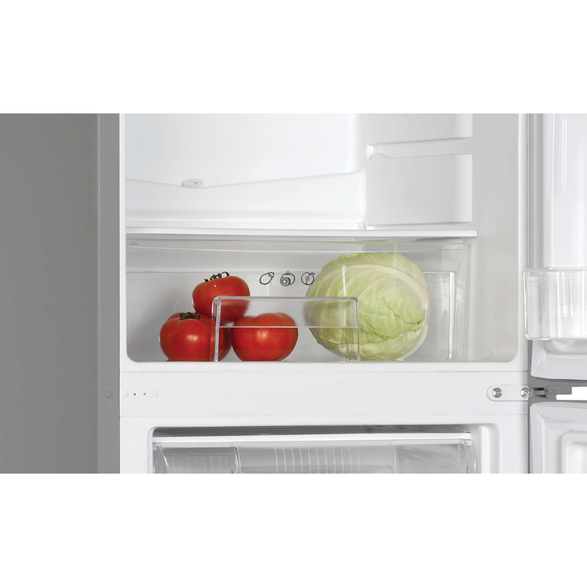 Un cajón de refrigerador con tomates y una col.