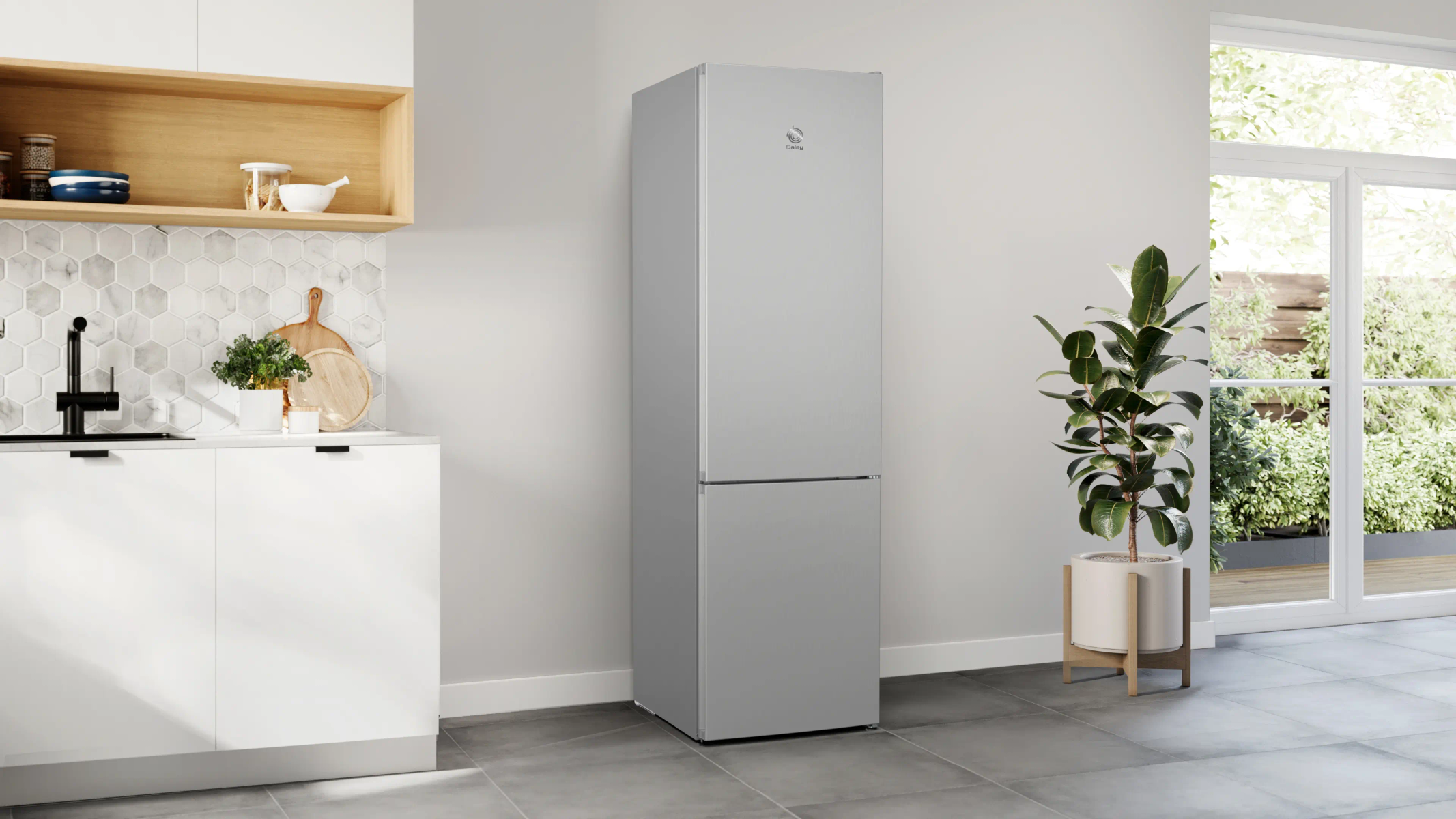 Un refrigerador plateado en una cocina moderna con gabinetes blancos y ventana.