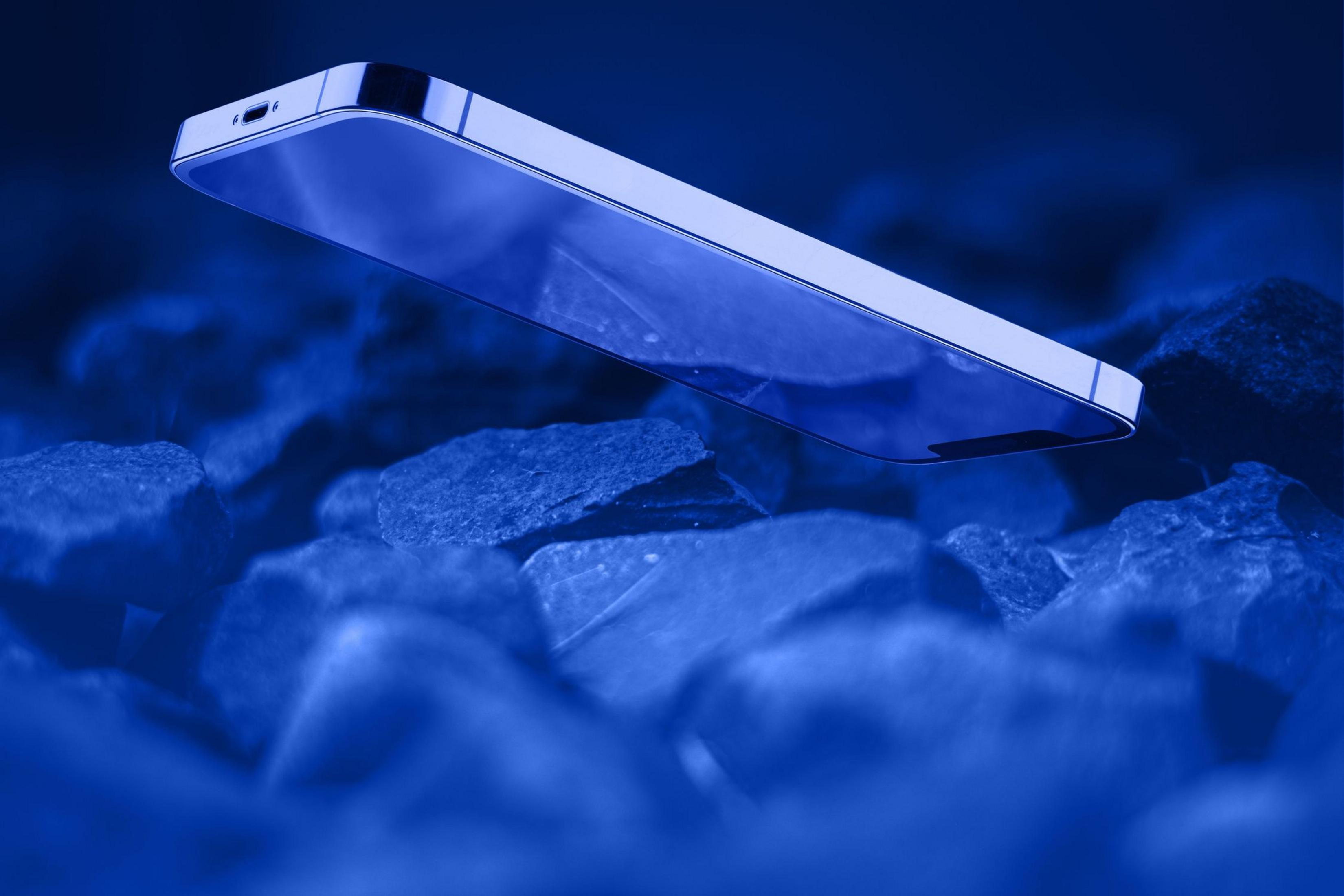 Uno smartphone blu fluttua su pietre. Le pietre sono visibili in primo piano e sullo sfondo.