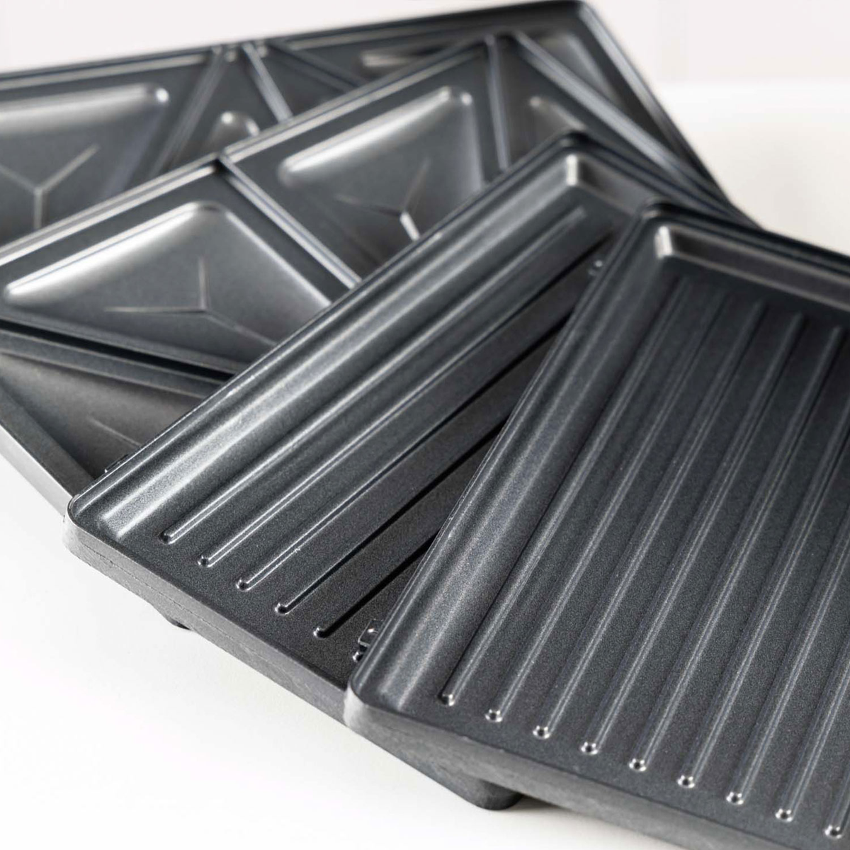 Piastre grigie per sandwich con scanalature e rientranze triangolari.
