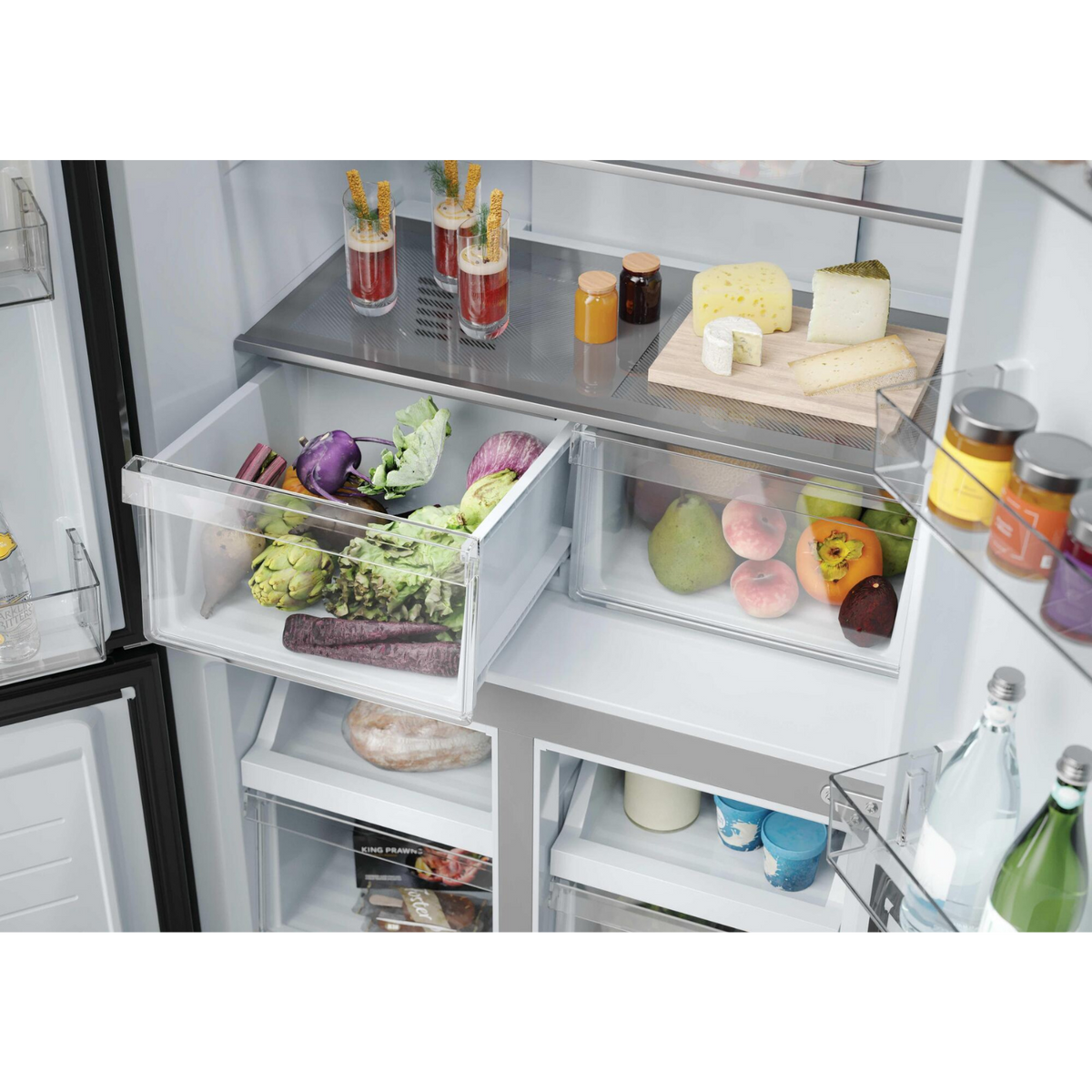 Cajones de refrigerador llenos de frutas, verduras, queso y bebidas.