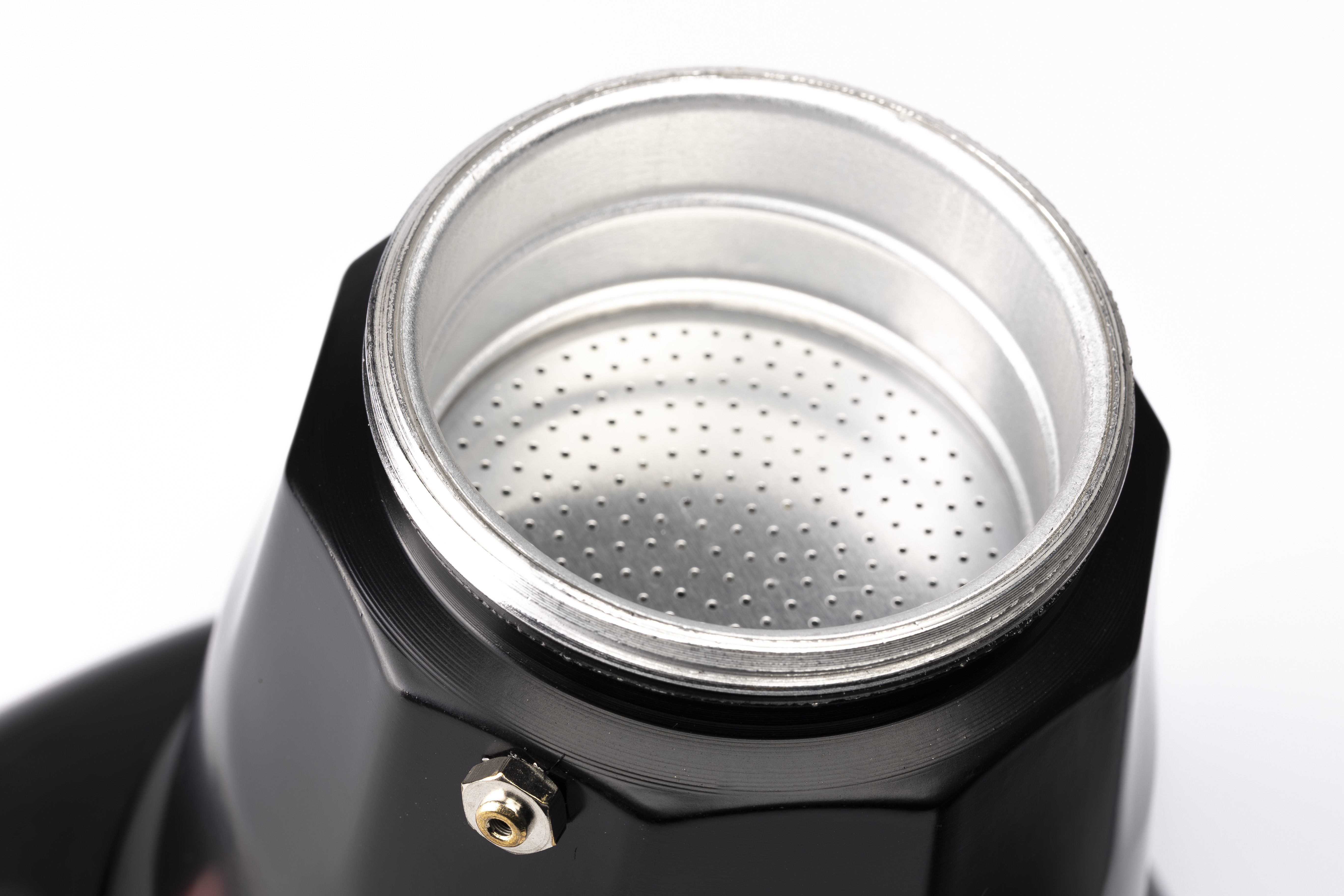 Primer plano de una cafetera Moka negra con filtro plateado.