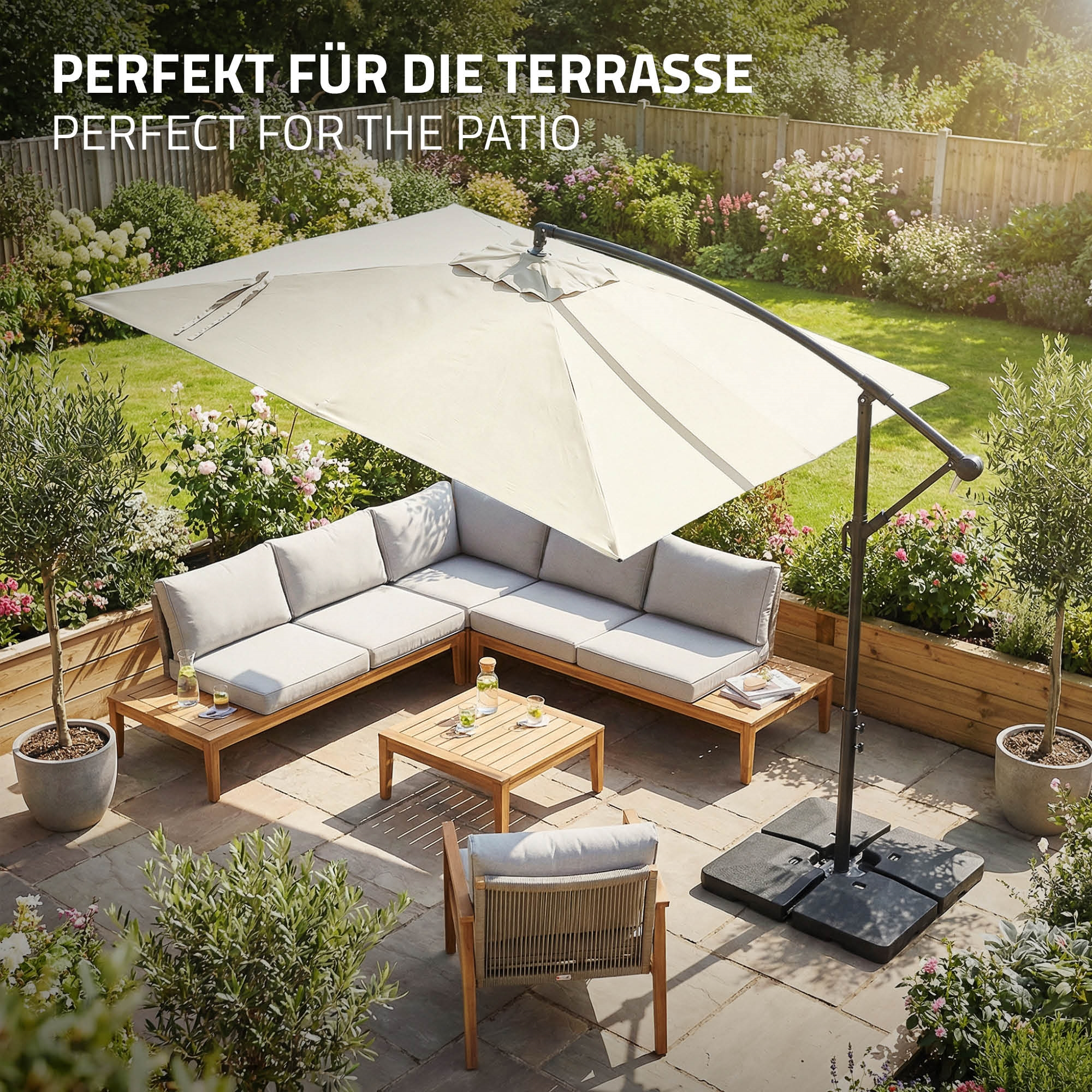 Gartenlounge mit Sonnenschirm auf einer Terrasse mit Blumen und Bäumen.