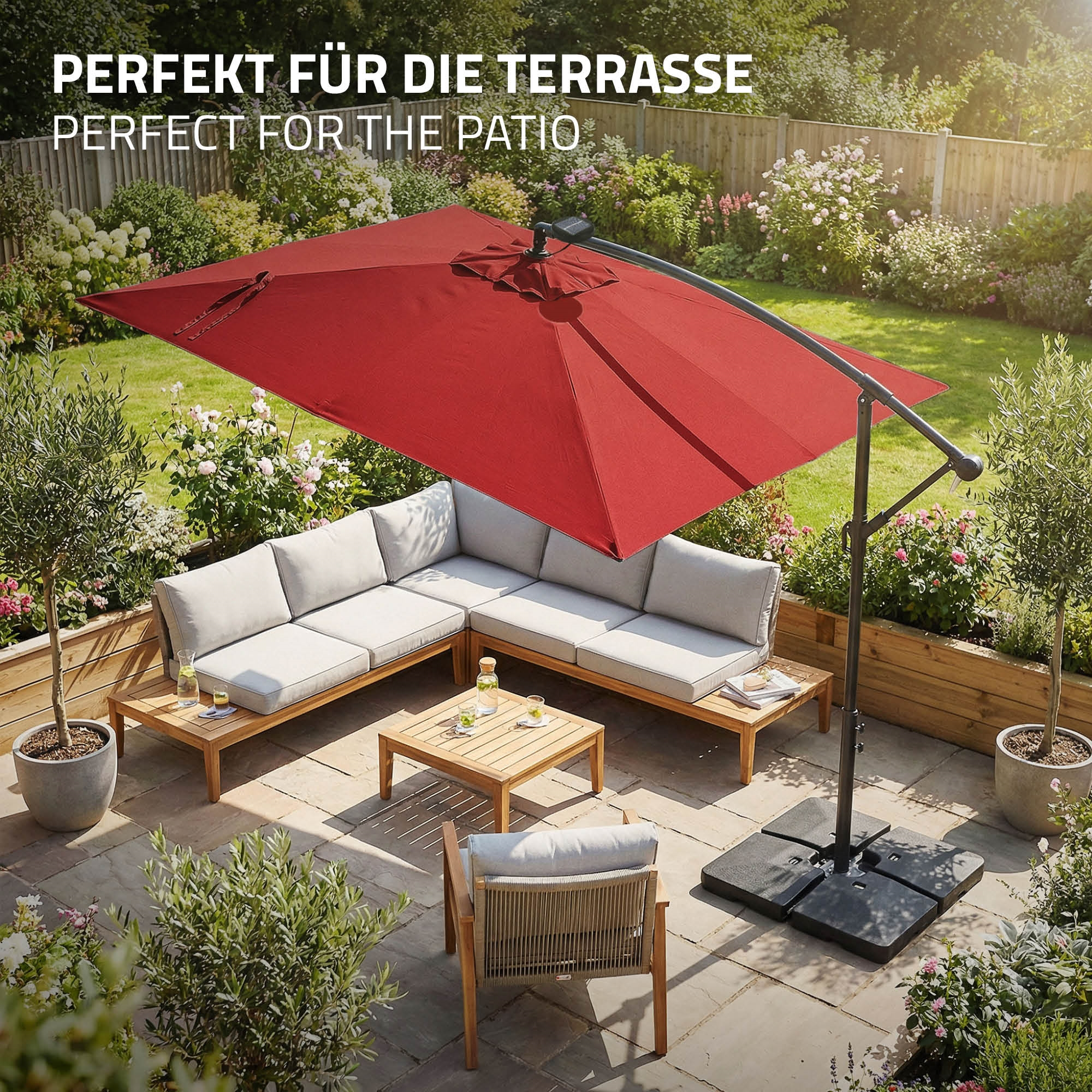 Terrassenmöbel mit rotem Sonnenschirm und Garten.