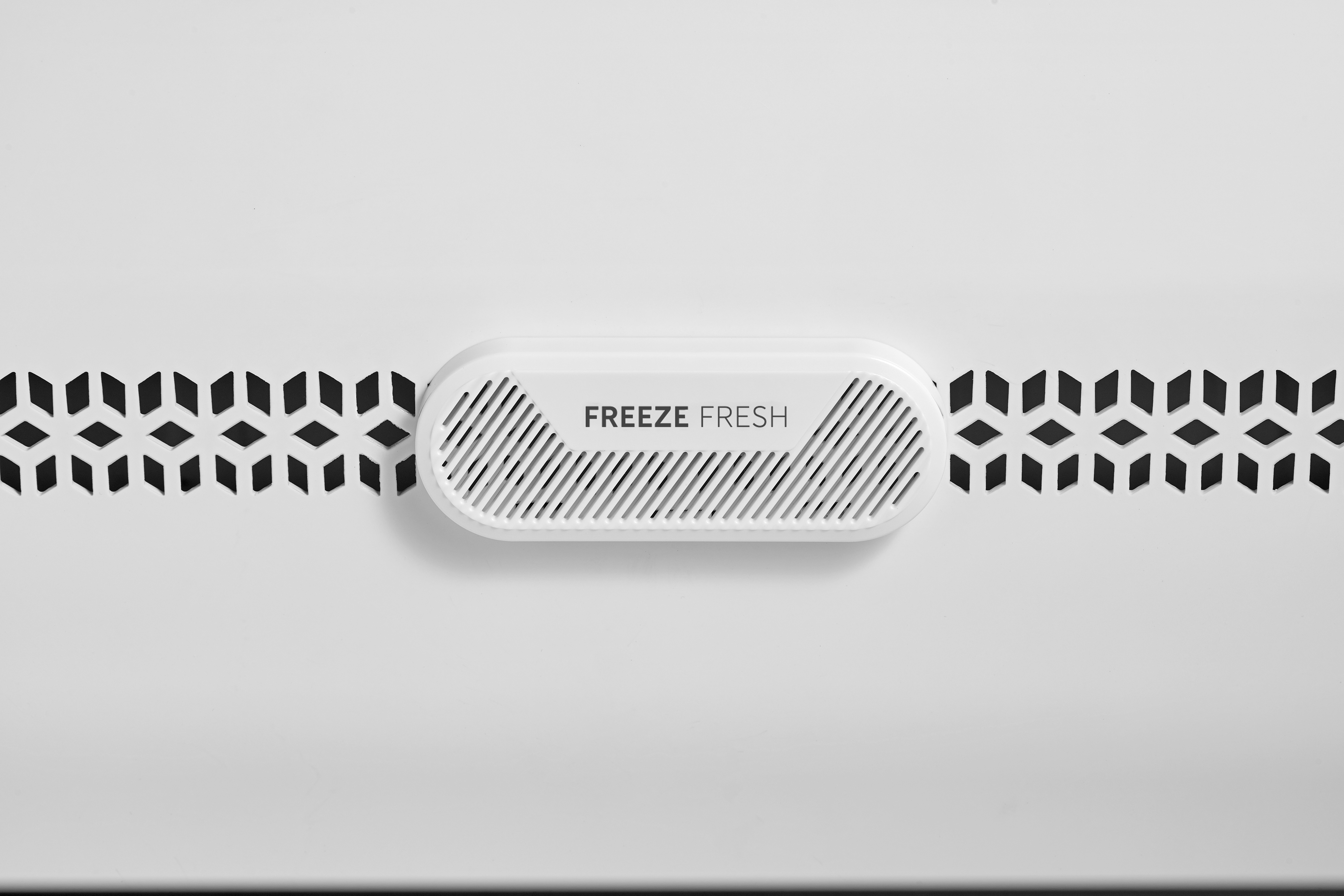 Ein weißer Lüftungsschlitz mit der Aufschrift „FREEZE FRESH“ und geometrischen Mustern.