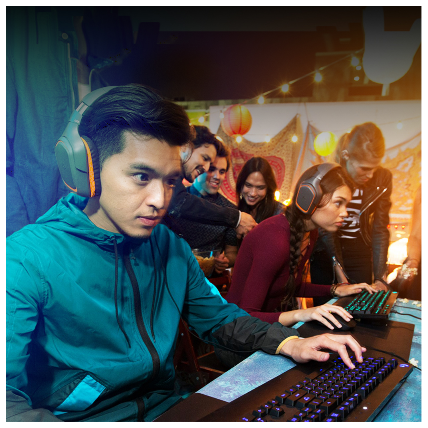 Młodzi ludzie w słuchawkach grają razem w gry wideo w pokoju z lampkami.