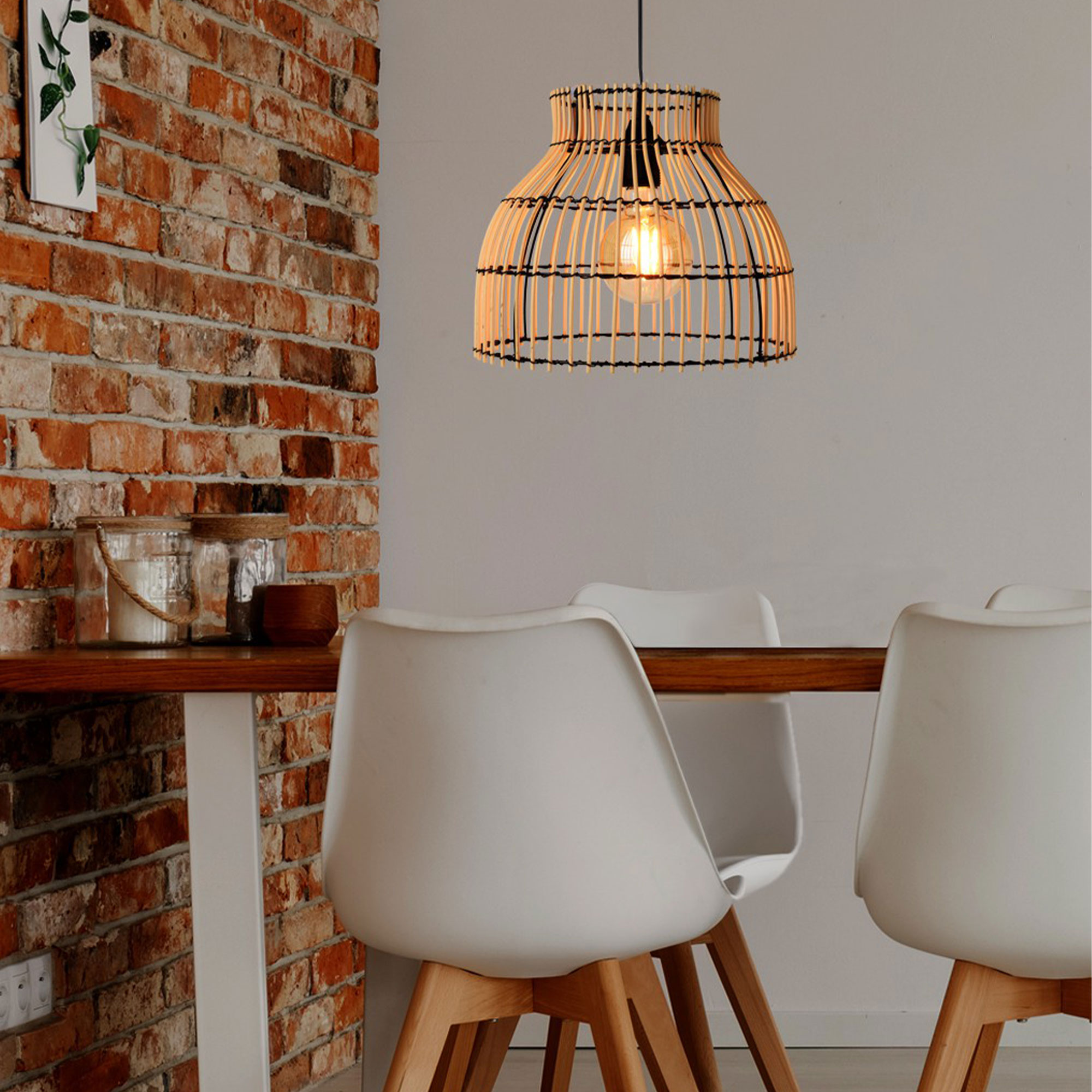 Una lámpara colgante tejida cuelga sobre una mesa de madera con sillas blancas.