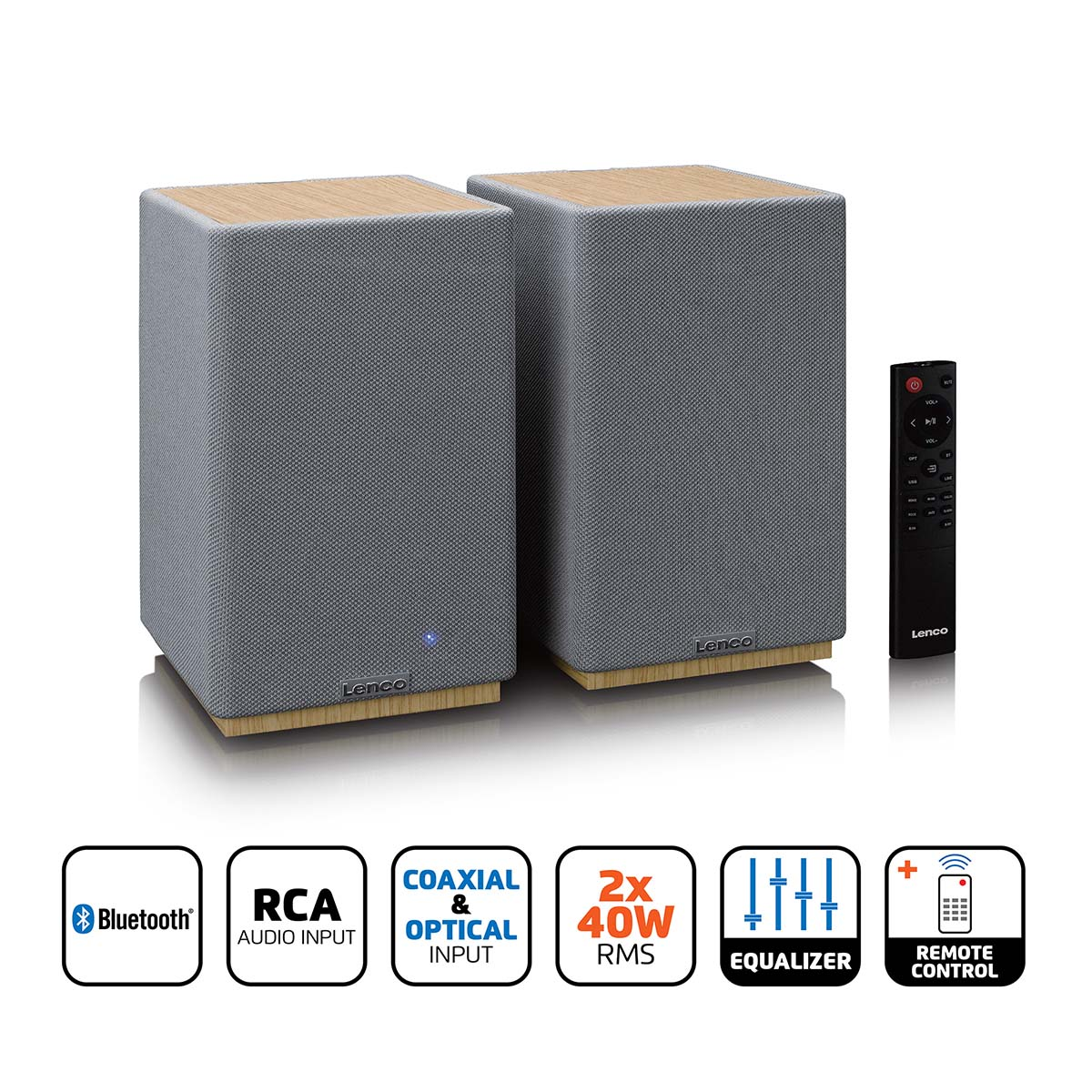 Dwa szare głośniki z drewnianym blatem i pilotem.