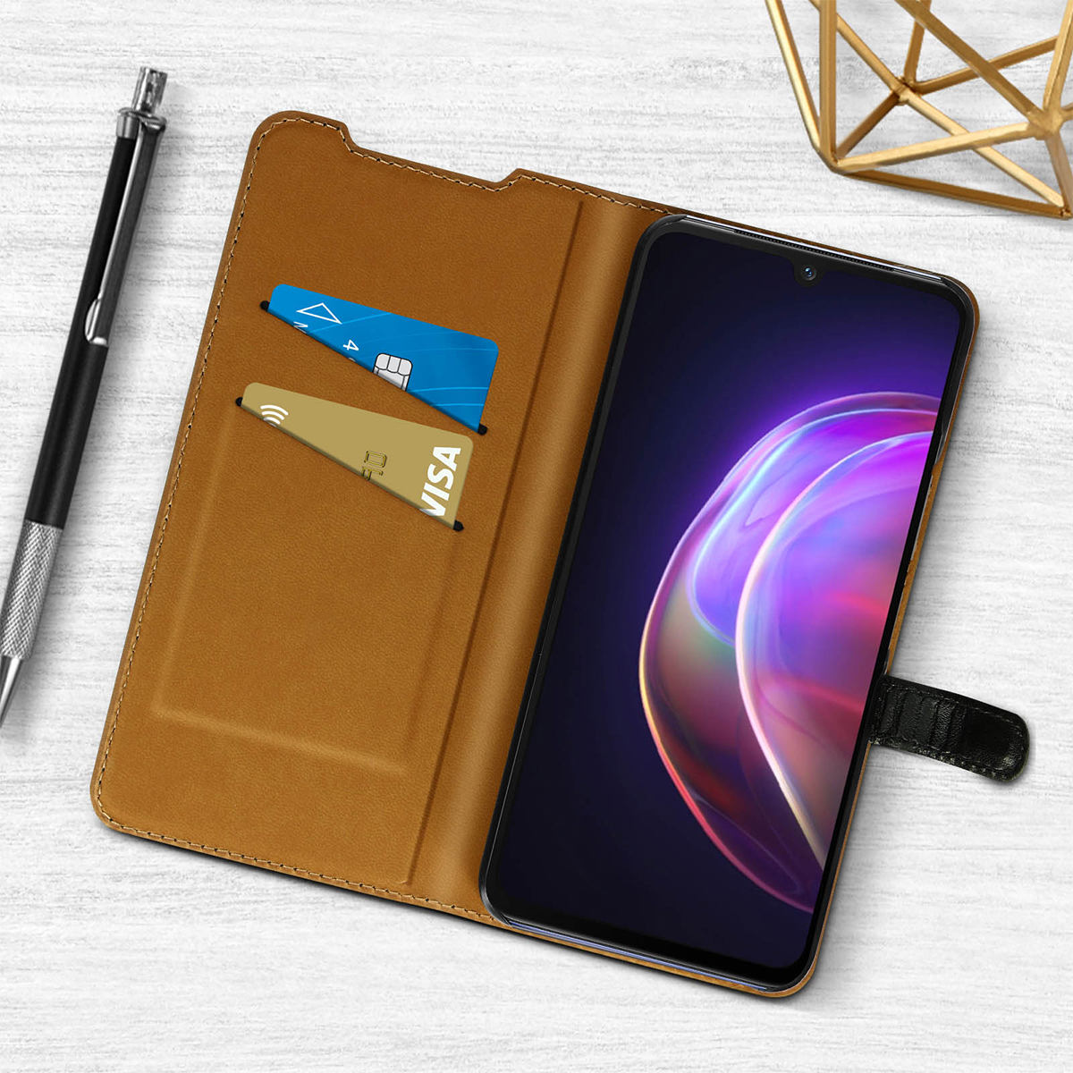 Una custodia per telefono marrone con due fessure per carte, una penna e un telefono.