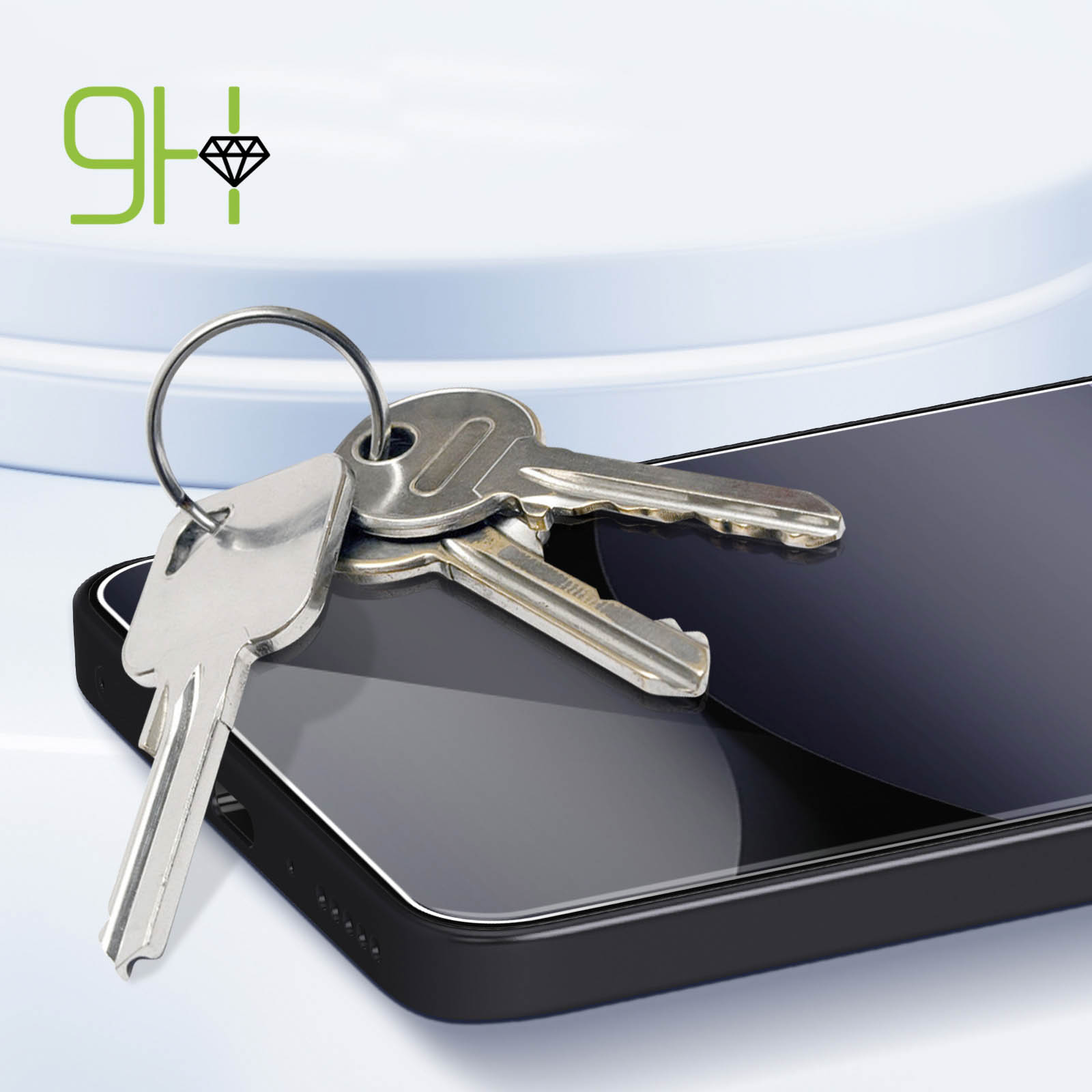 Un mazzo di chiavi poggia su uno smartphone scuro con proteggi schermo.