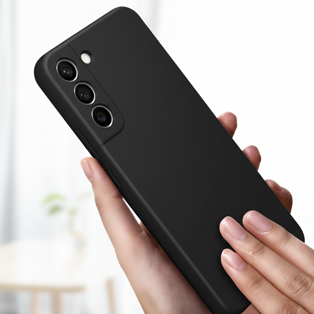 Una mano sostiene un smartphone negro con tres cámaras traseras, fondo desenfocado.