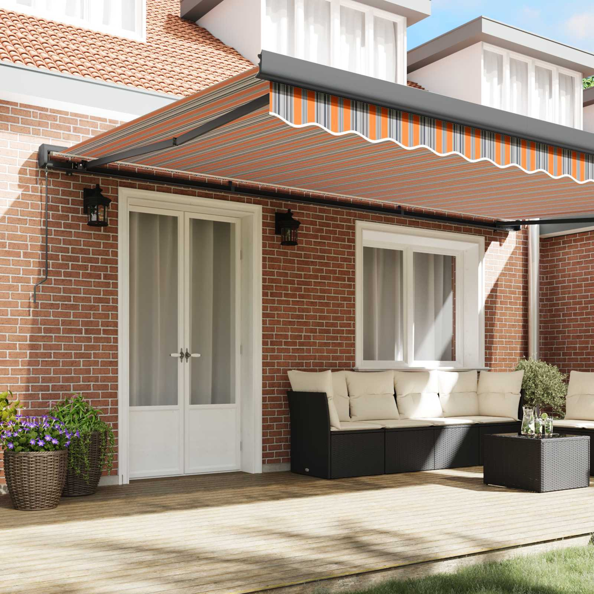 Eine Markise mit orangen und grauen Streifen über einer Terrasse mit Möbeln.