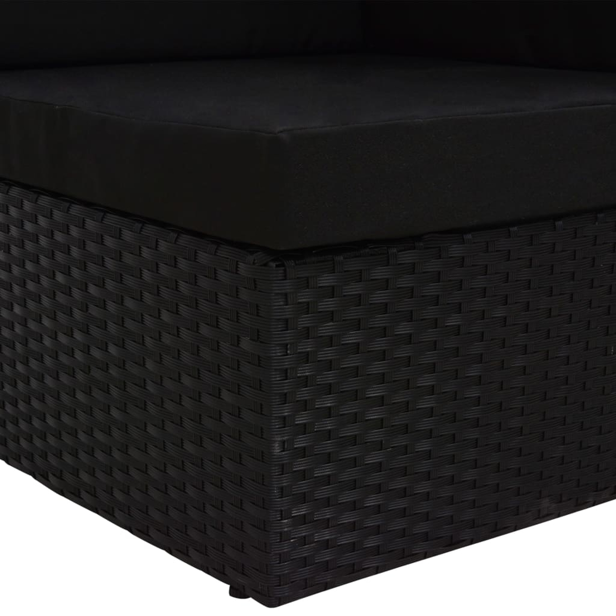 Nahaufnahme eines schwarzen Rattansofas mit Kissen.