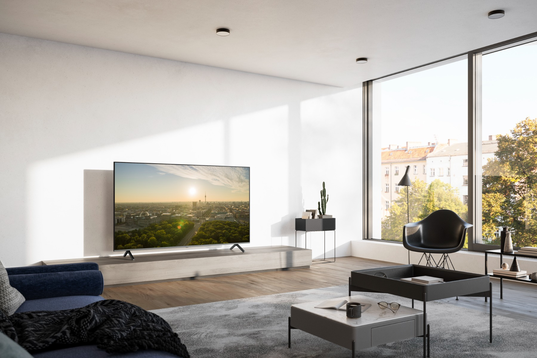 Modernes Wohnzimmer mit großem Fenster, Fernseher zeigt Stadtblick.