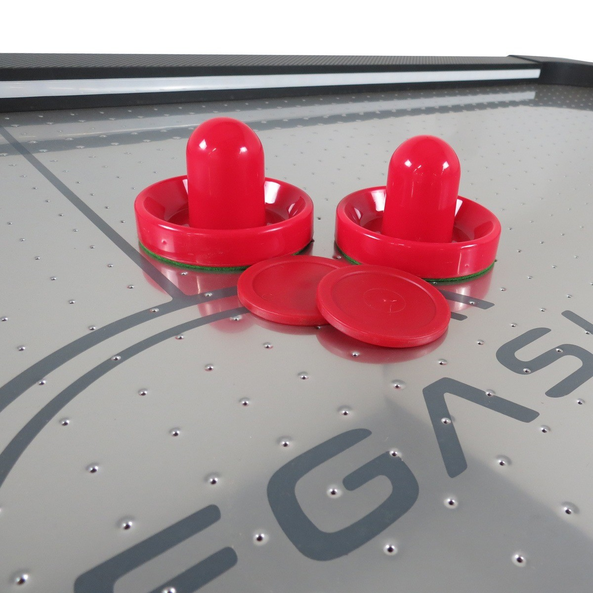 Twee rode airhockey pucks en twee rode hamers op een zilveren tafel met grijze markeringen.