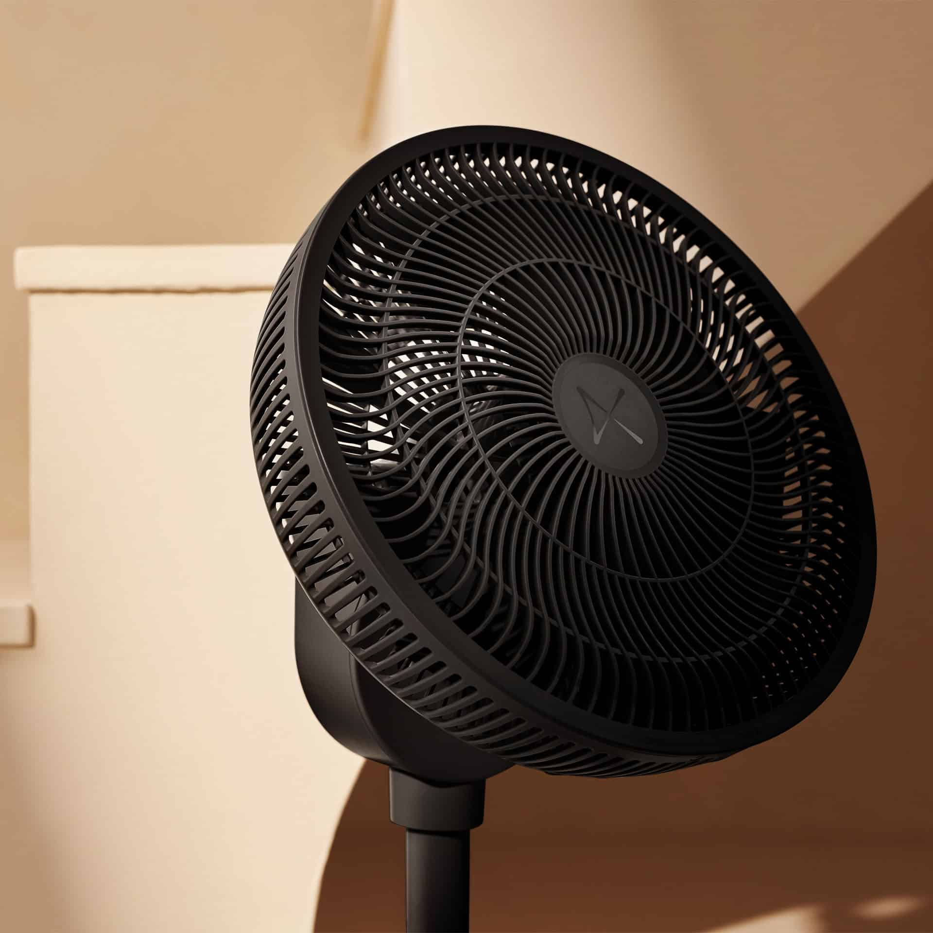 Un ventilateur sur pied noir avec une grille ronde est présenté sur fond beige.