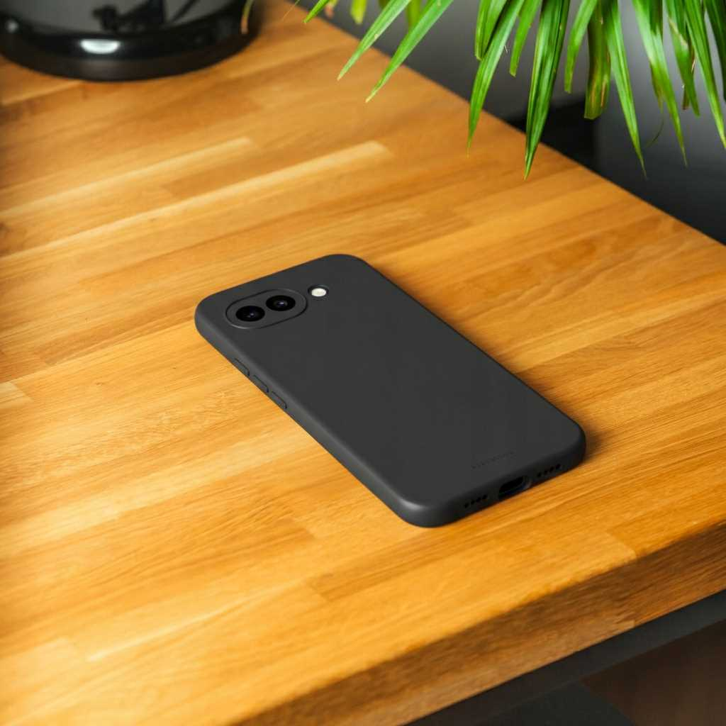 Czarny smartfon z aparatami leży na drewnianym stole.