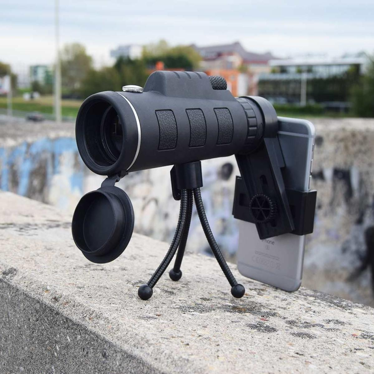 A black monocular on a tripod with a smartphone attached.